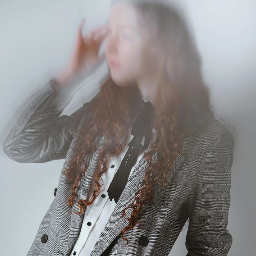 Woman in business blazer with a blurred, motion-distorted effect — visually representing the exhaustion and mental fog of burnout coaching for women entrepreneurs.