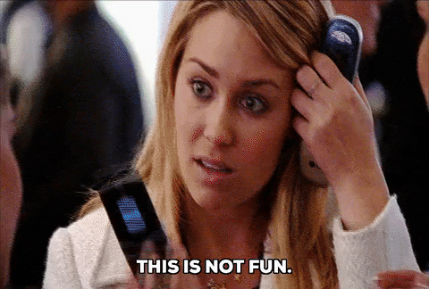 Overwhelmed woman holding two phones with the caption This is not fun, a gif for the August Productivity Rebellion reset.