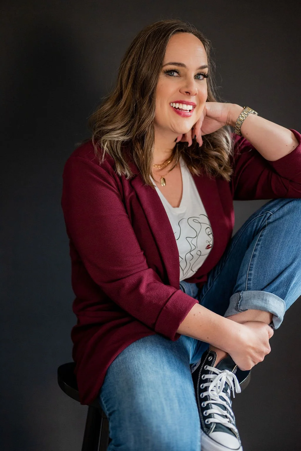 Cara Chace in red blazer and jeans, smiling in a branding image for coaching women entrepreneurs through burnout, productivity, time management, and business struggles