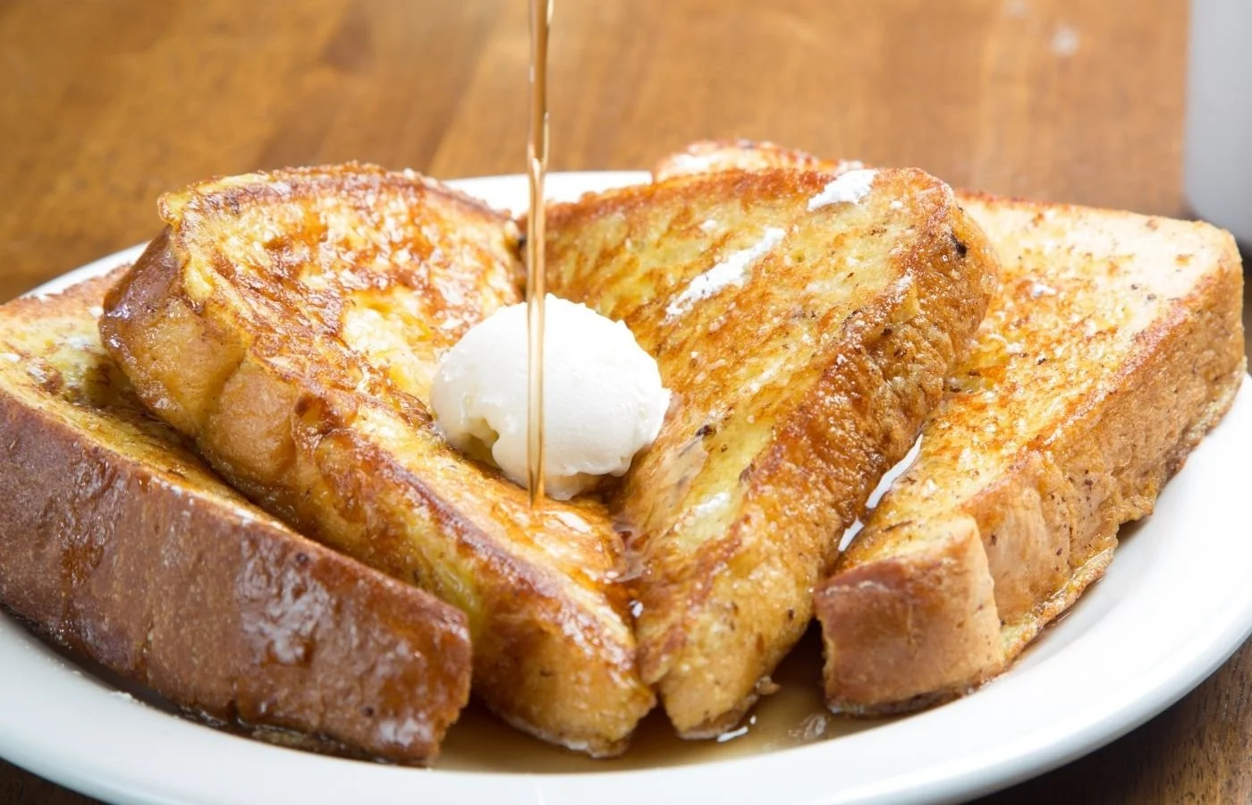 French toast with butter and pouring syrup