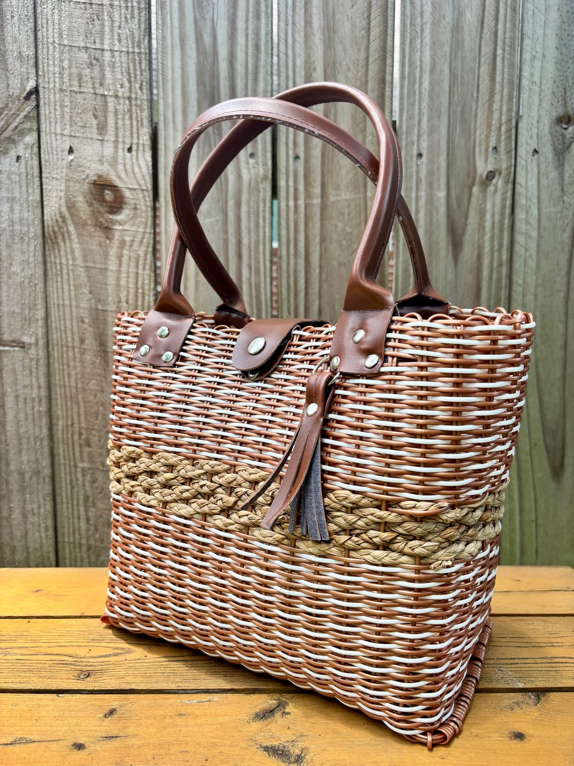 Brown handbag made from recycled plastics faux leather handles.