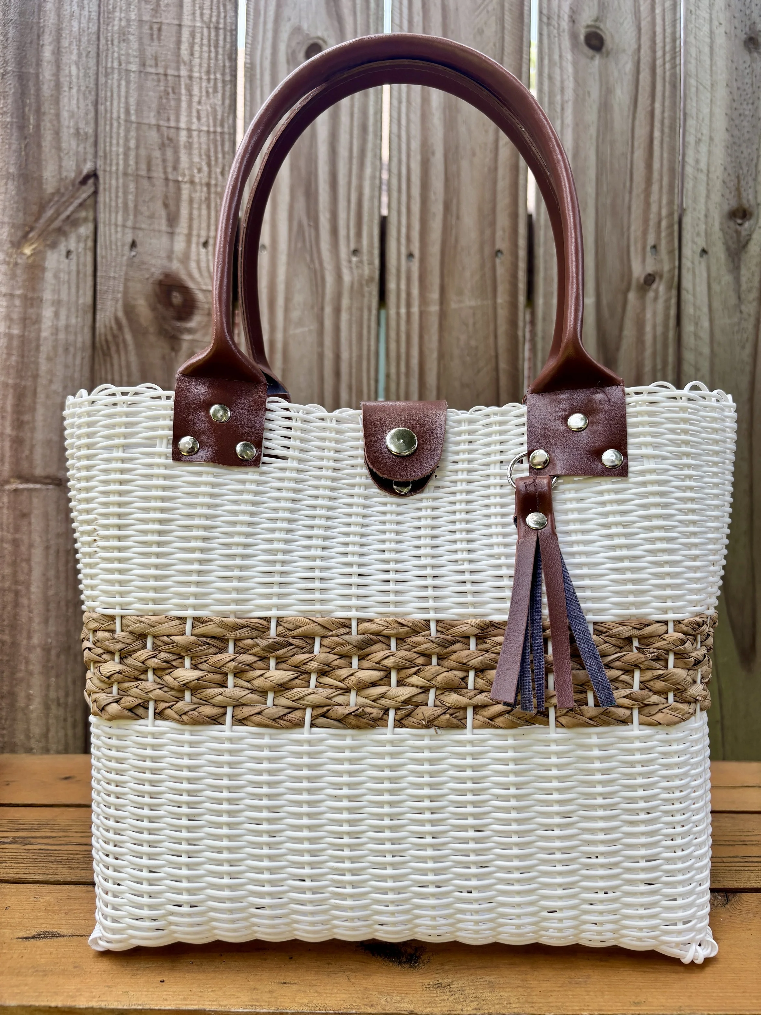 Handwoven bag made with faux leather handles.