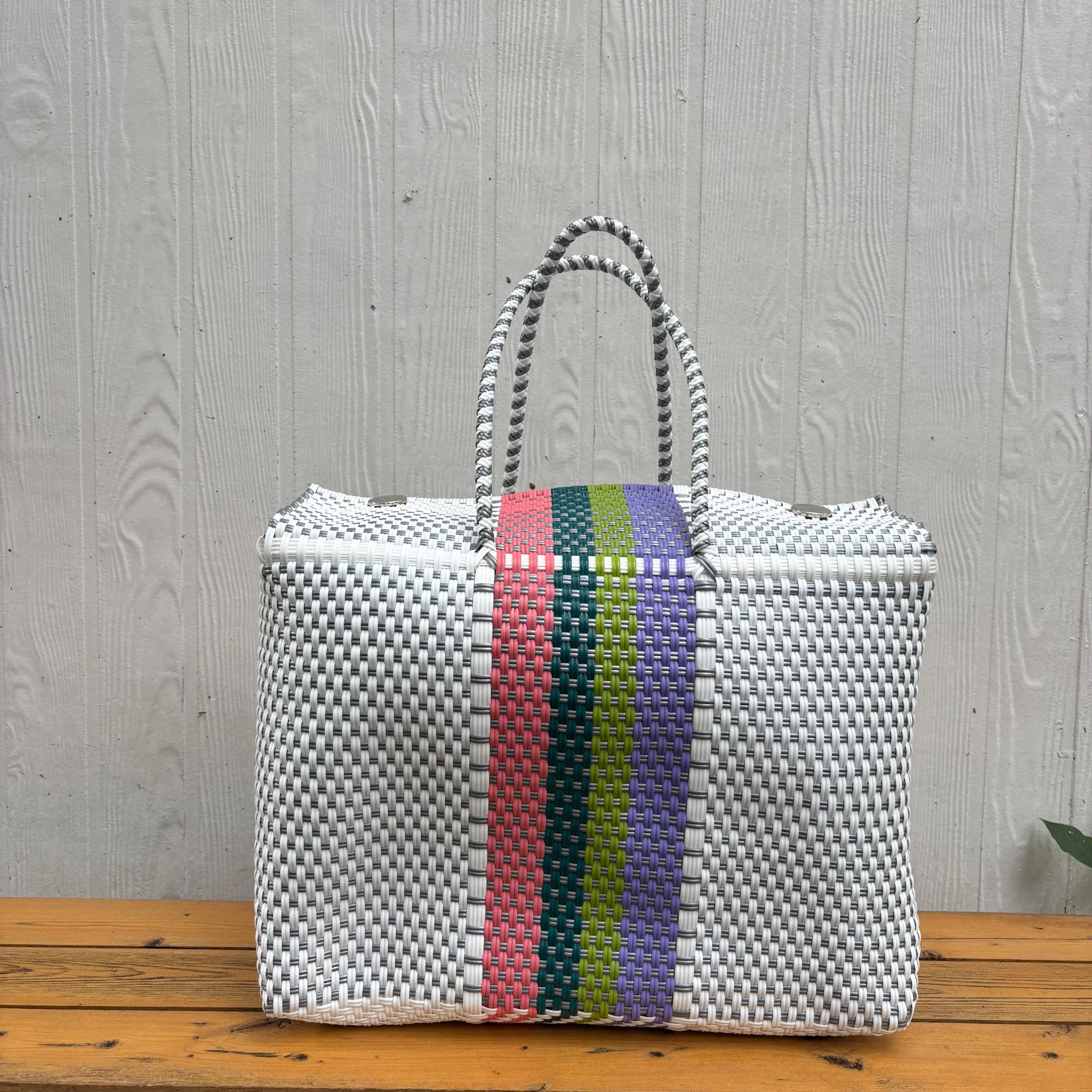 White and colorful stripes duffle bag on a bench