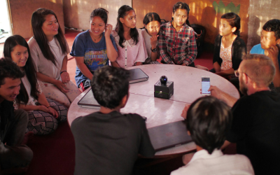 Multiple young people sitting around a table smiling and chatting. Sarah Bryski-Hamrick. Philly therapist