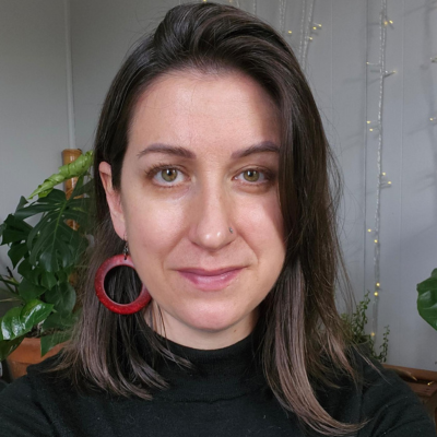 Woman smiling into camera, red earrings. Cancer depression therapist Pennsylvania Sarah Bryski-Hamrick