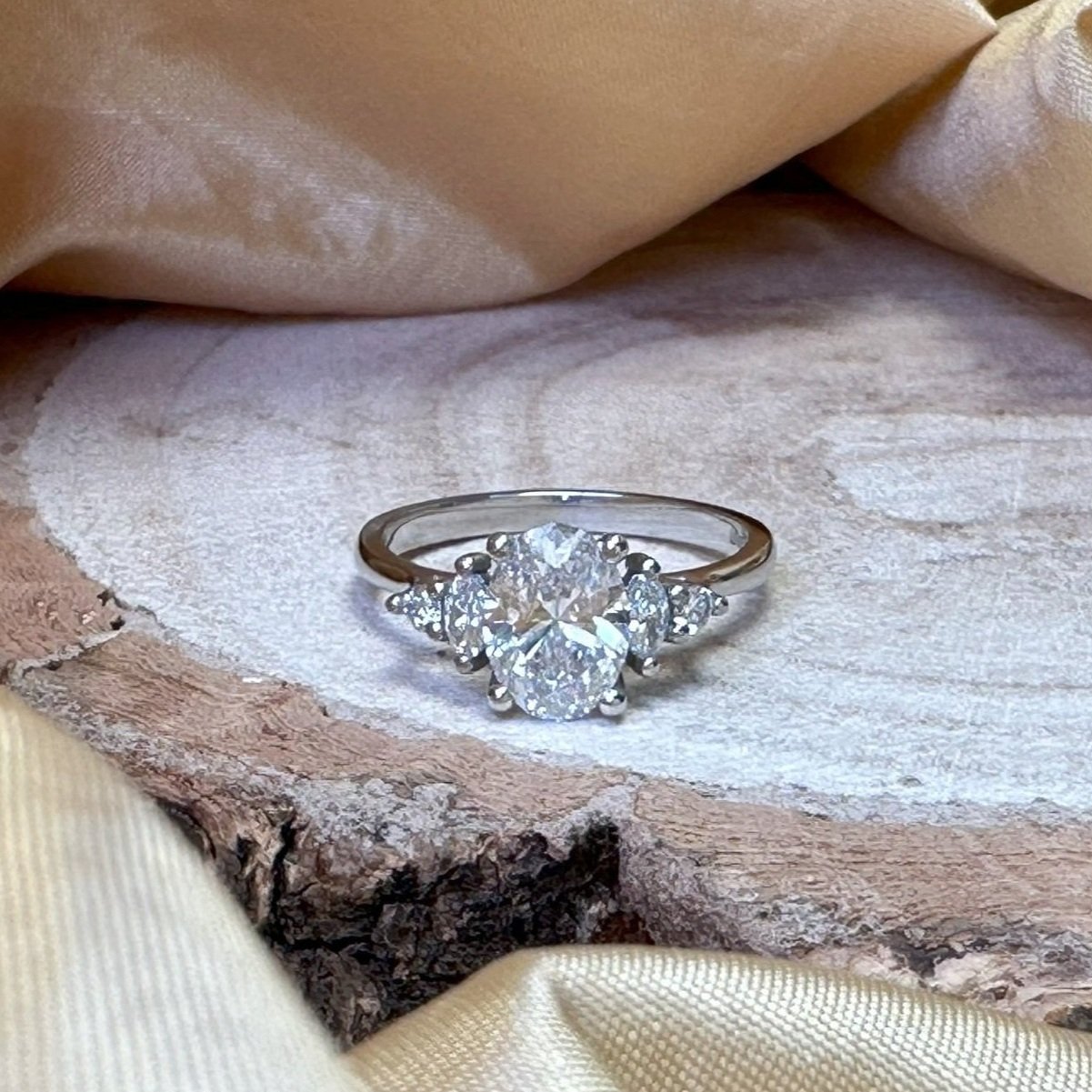 Bespoke engagement ring with an oval diamond centre and marquise and pear shaped side stones.