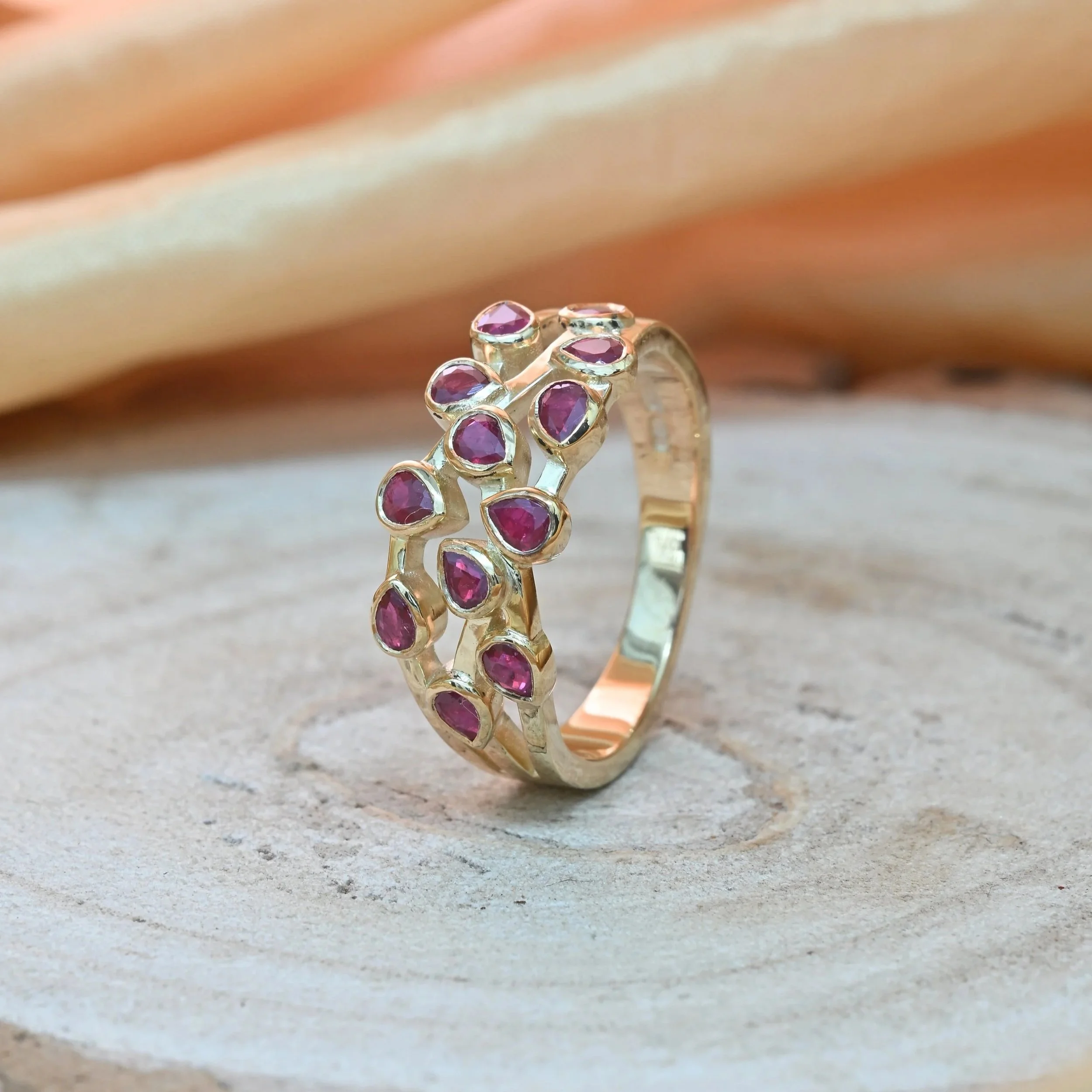 Bespoke ruby scatter ring made using repurposed pear shaped rubies from customers old earrings