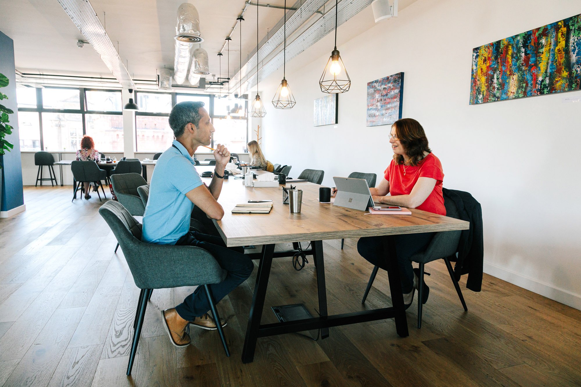 image of marketing consultant talking with a client in an open plan office