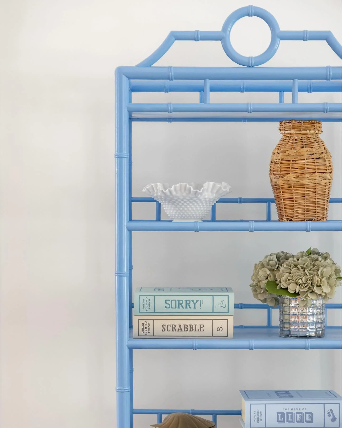 getting up close and personal with the living room at the #preppyhollowhouse! let&rsquo;s take a closer look at some of the details in the space, from the bold blue &eacute;tag&egrave;re stacked with vintage book-inspired board games to the faux bamb