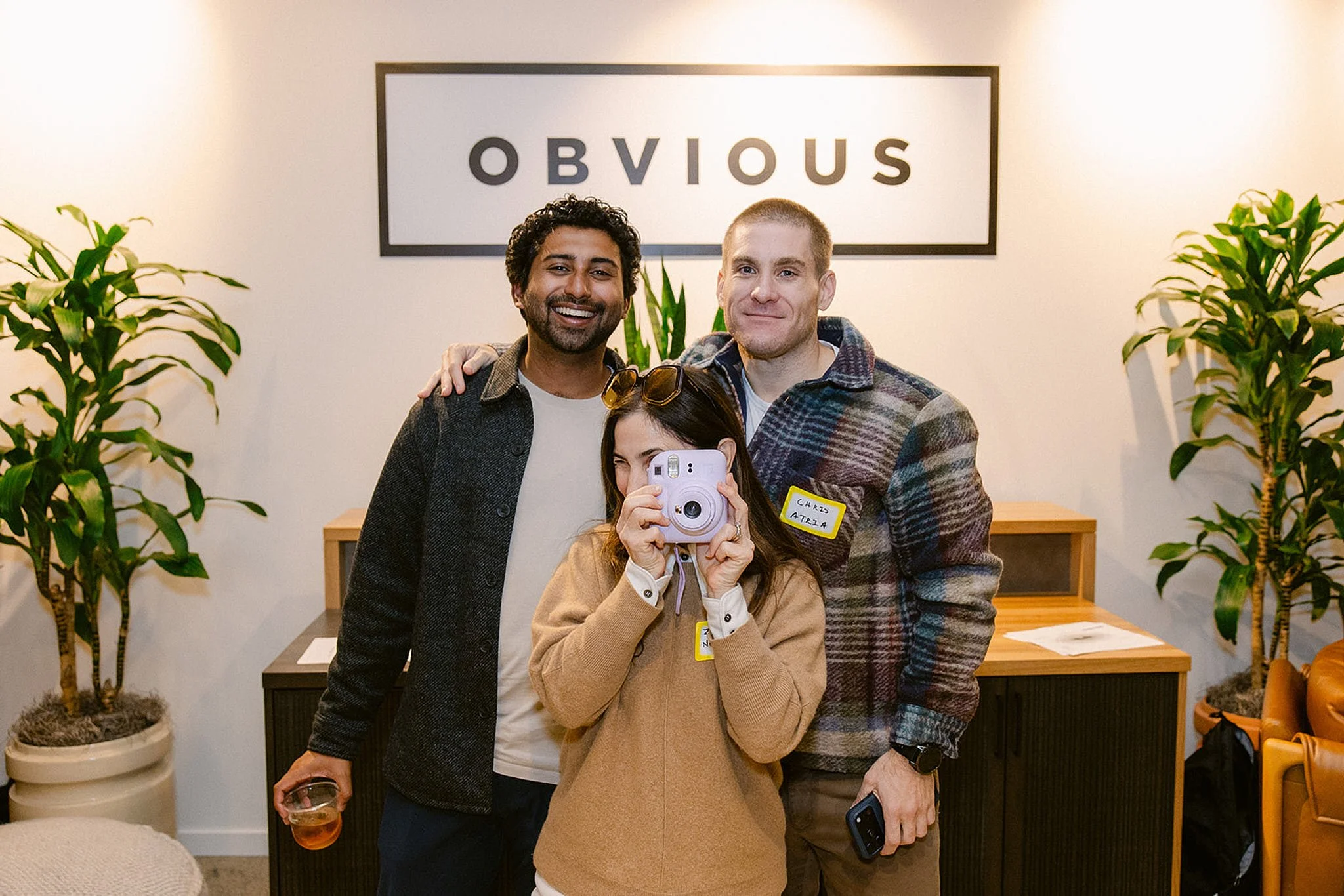 The Obvious Ventures team smiling in front of a branded office sign during a corporate event in San Francisco. High-end branding photography by Michaela Joy Photography.