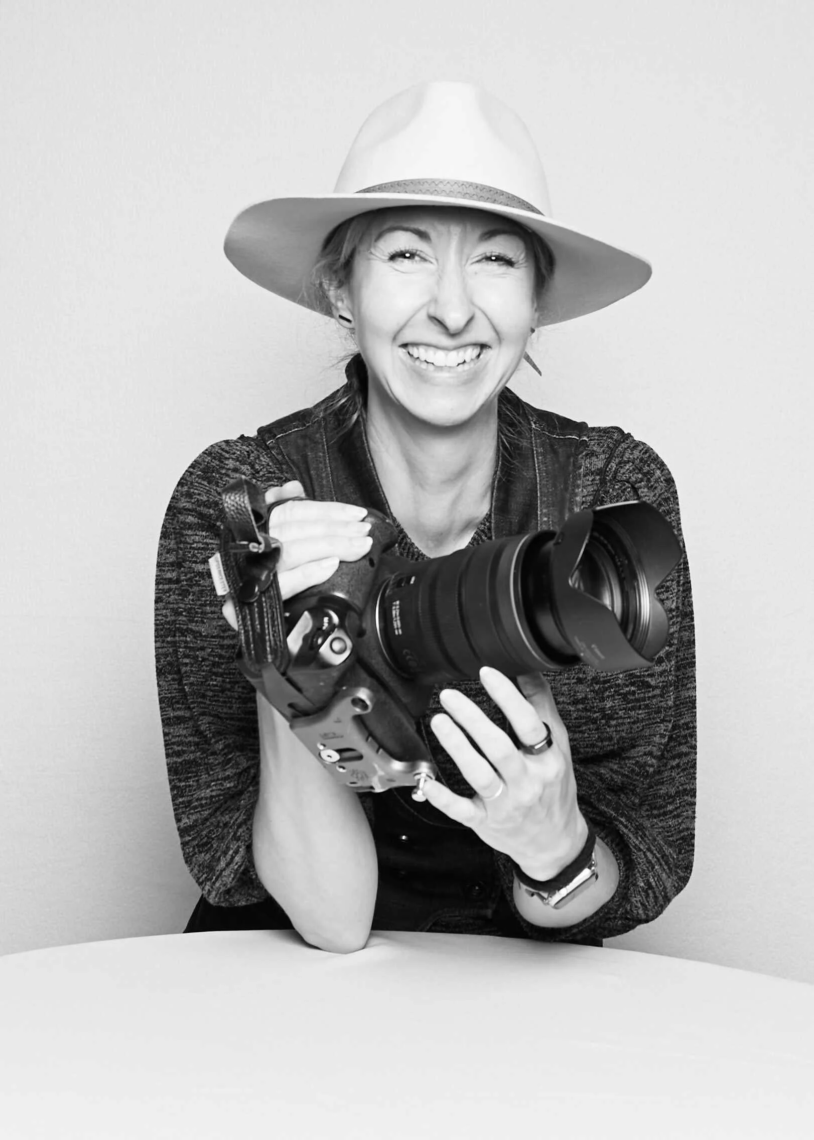 Michaela Joy smiling with her camera, photography business coach helping photographers scale their pricing and client experience.