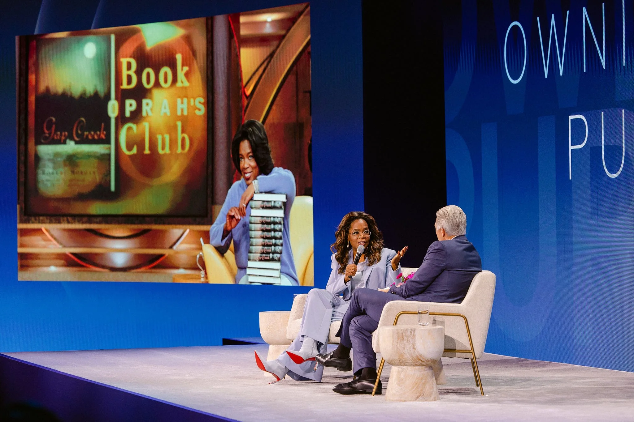 Oprah Winfrey on stage during a candid conversation about the OWN Book Club at a high-profile retreat. Expert high-profile event photography in California by Michaela Joy Photography.
