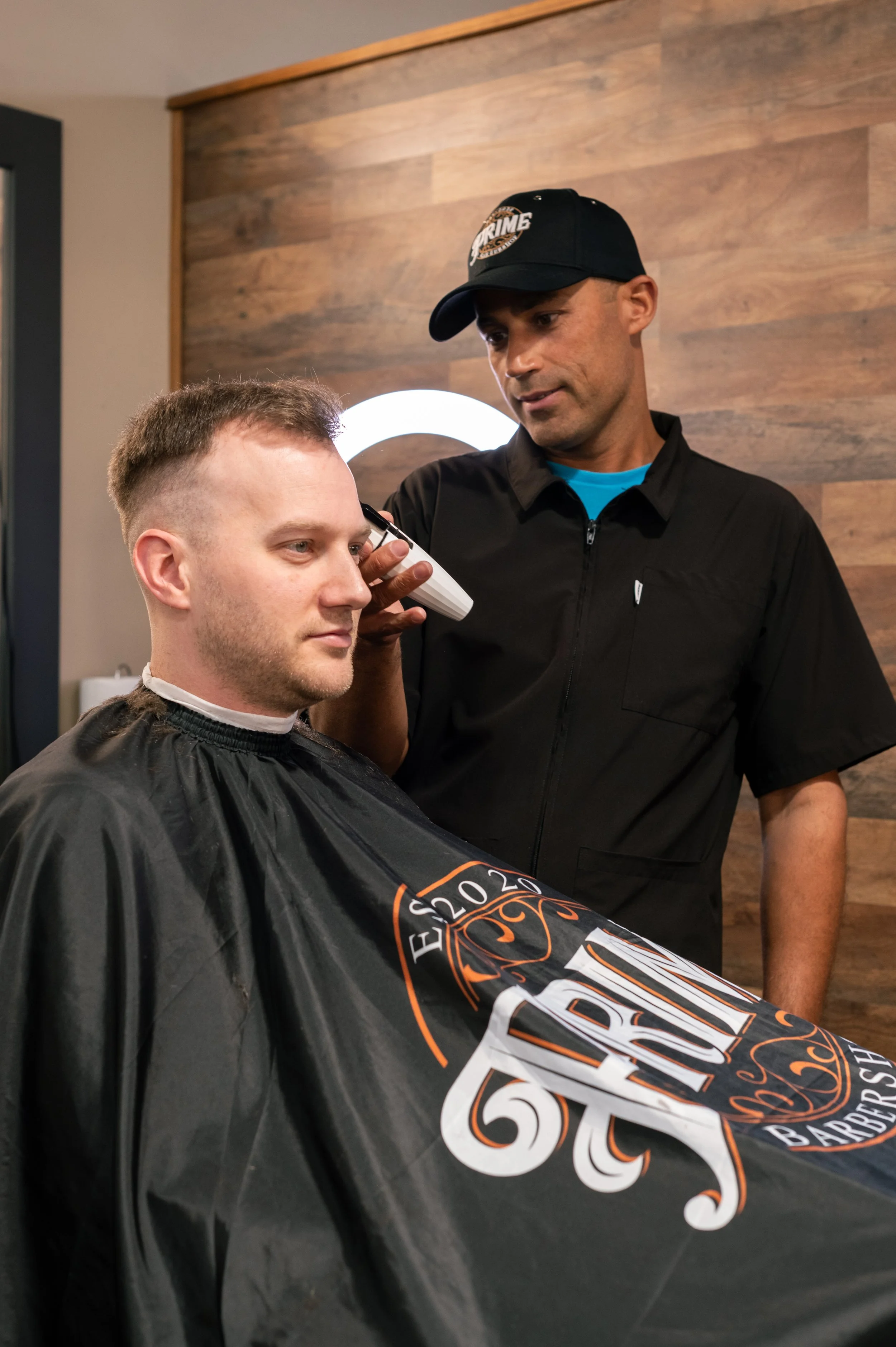 A man getting a haircut at a barber shop.