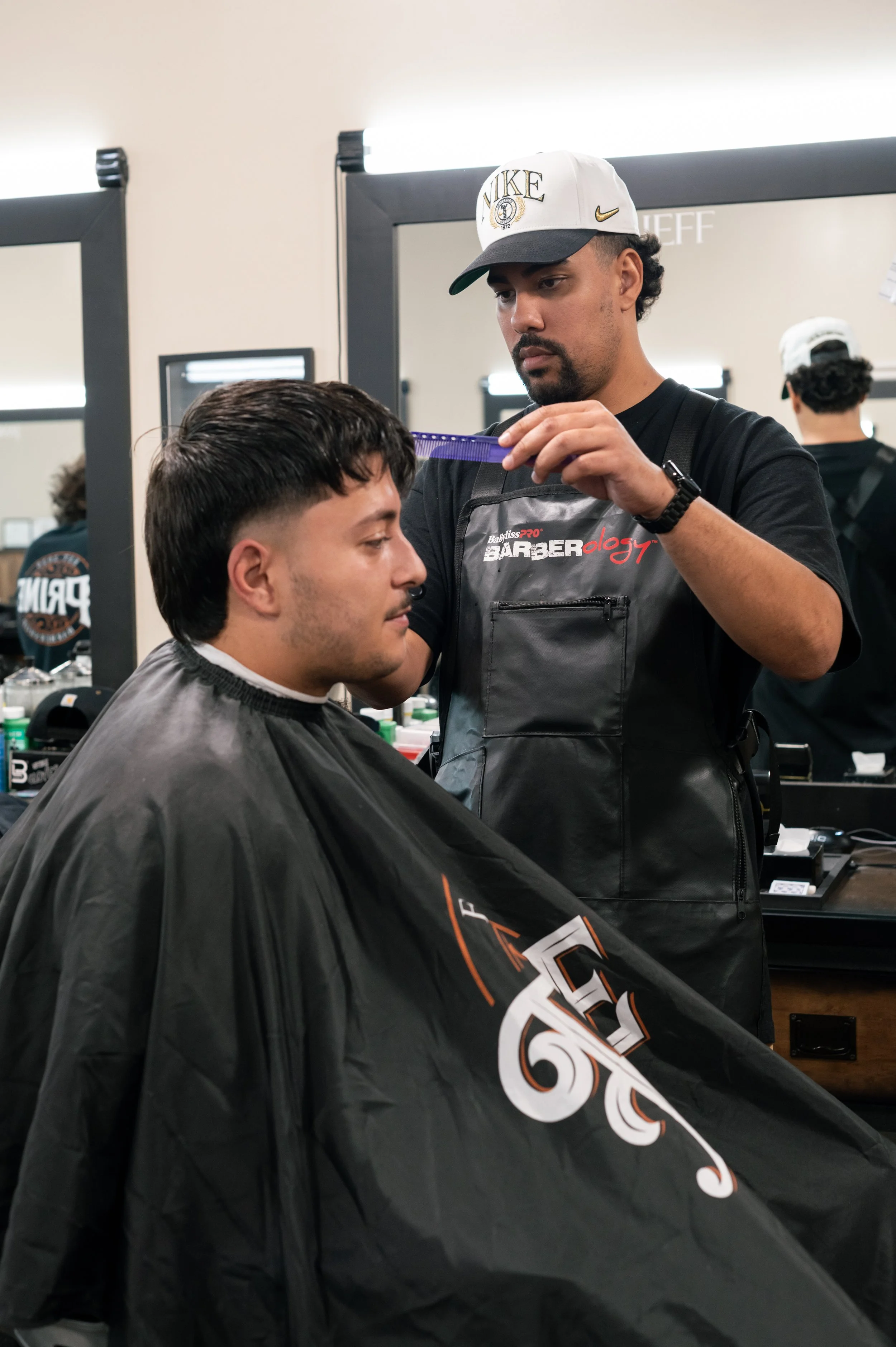 Barber cutting a man's hair in a barbershop.
