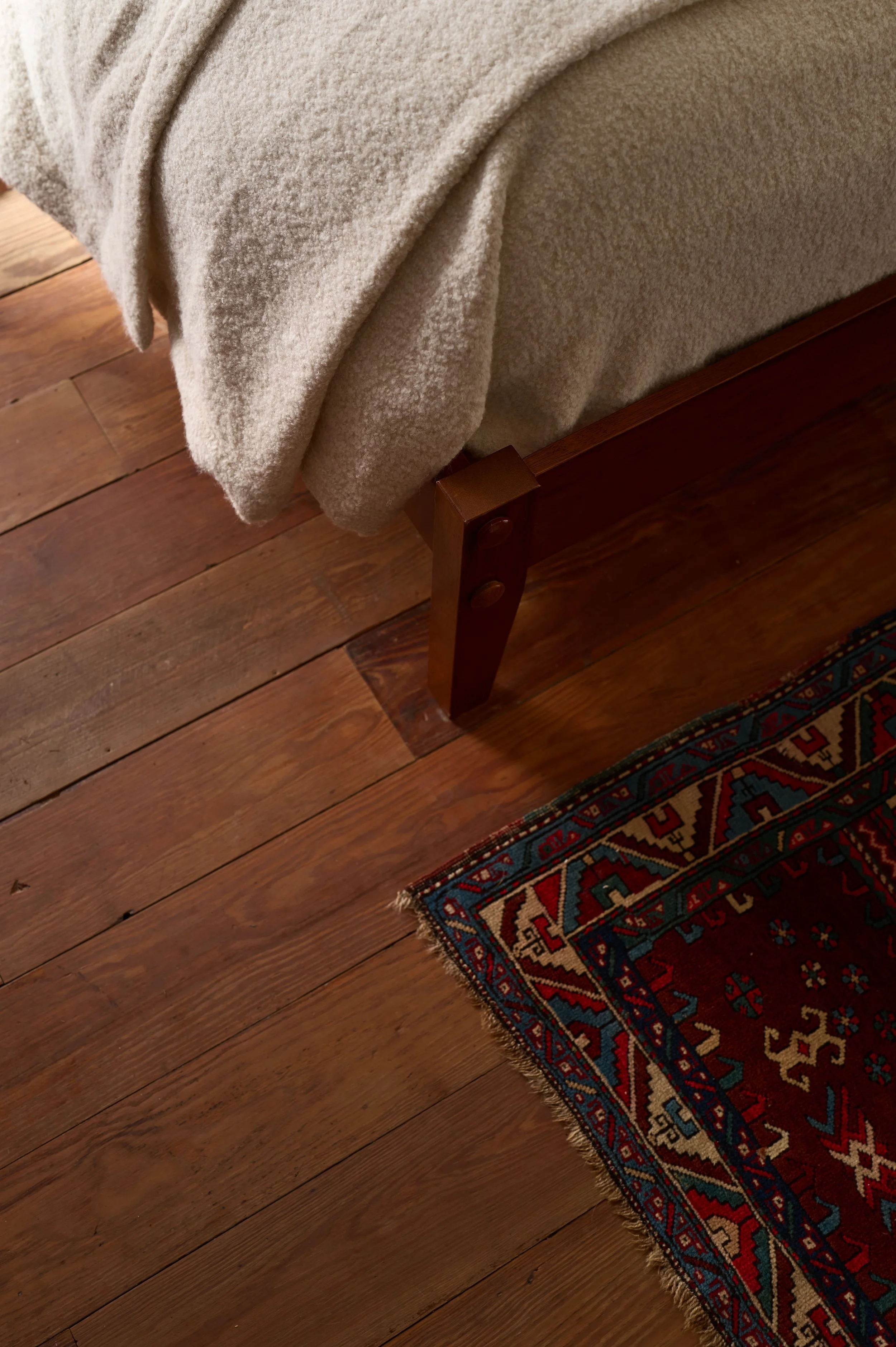Bedroom wood flooring detail with a vintage patterned rug at the foot of the bed, Alamo Farmhouse (Jackson Way) architecture and furnishing remodel by Spearman Spaces
