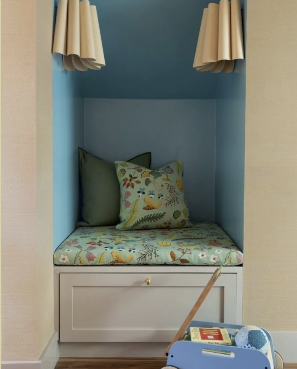 Built-in window seat nook in a children's bedroom with sky blue walls, scalloped linen curtains, a floral cushion and matching throw pillow, Transitional Italianate comprehensive remodel (De Haro Street, Potrero Hill) by Spearman Spaces