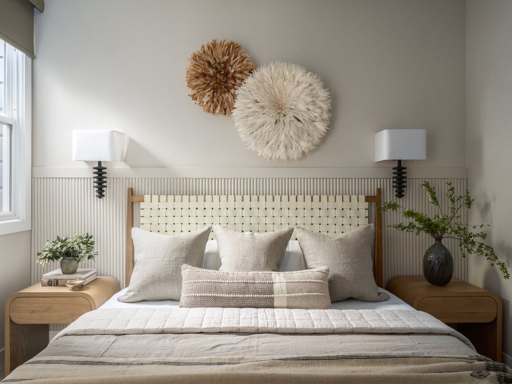 Bedroom detail with striped bedding and juju hat wall art, San Francisco Craftsman Victorian gut renovation by Spearman Spaces