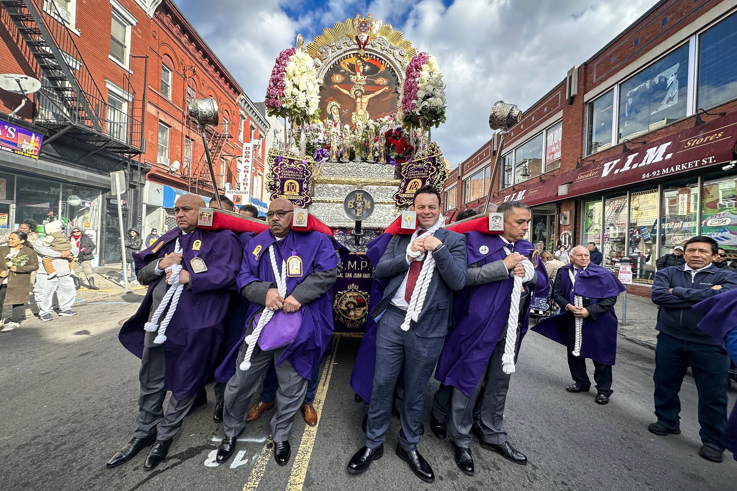 PATERSON, N.J. | Nov. 16, 2025: Paterson Mayor Andre Sayegh joins the ‘cargadores’ during the Señor de los Milagros (“Lord of Miracles”) procession along Market Street, a major Peruvian Catholic tradition. Dressed in purple robes, the cargadores carr