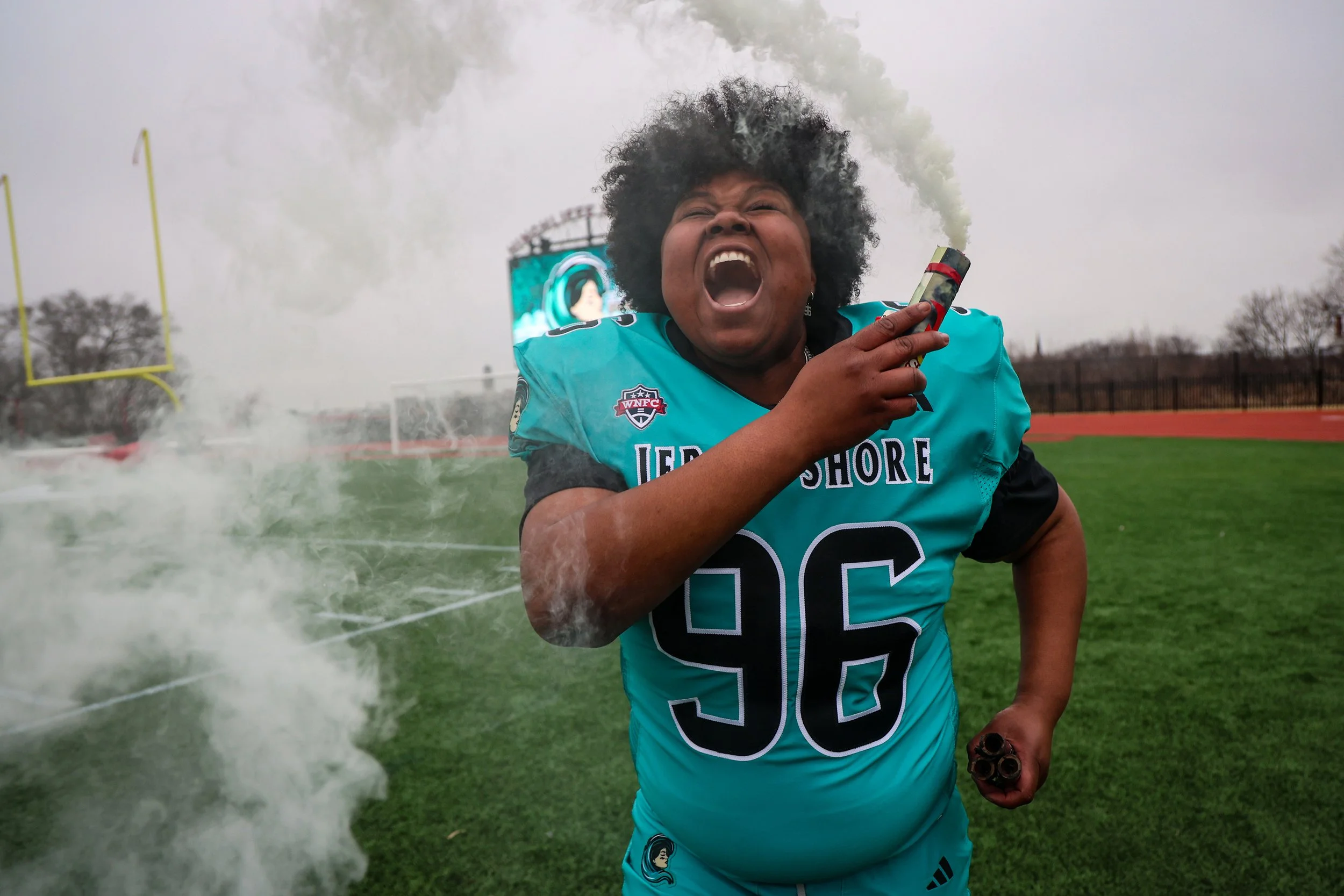 PATERSON, N.J. | 04-05-25: Jersey Shore Wave player Demiera Lockhart twirls a smoke flare during media day as the team prepares to make history by playing the first women’s professional tackle football game ever held in New Jersey. The team will play