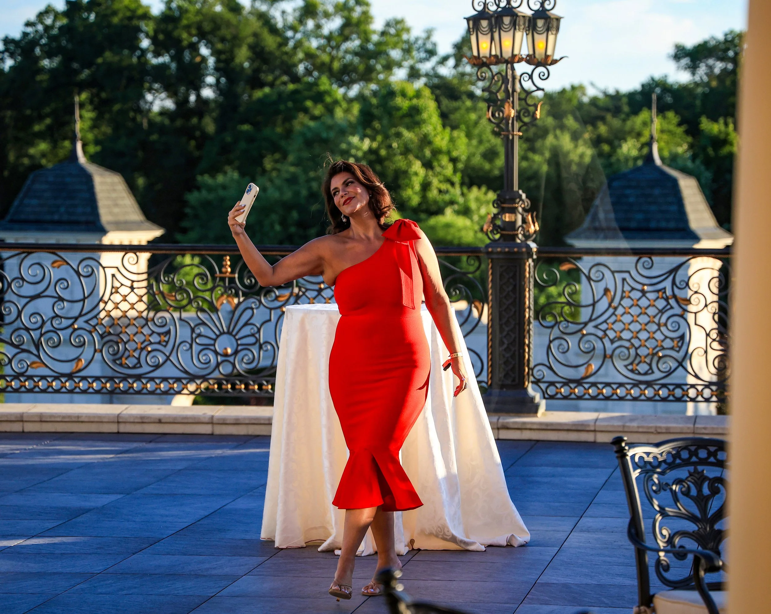 WAYNE, N.J. | July 18, 2025: A woman dressed in red—the color of the Peruvian flag—poses for a selfie in the fading light on the terrace of The Legacy Castle during The Peruvian Parade Inc.’s 39th Annual Gala, marking the start of Peruvian Heritage M