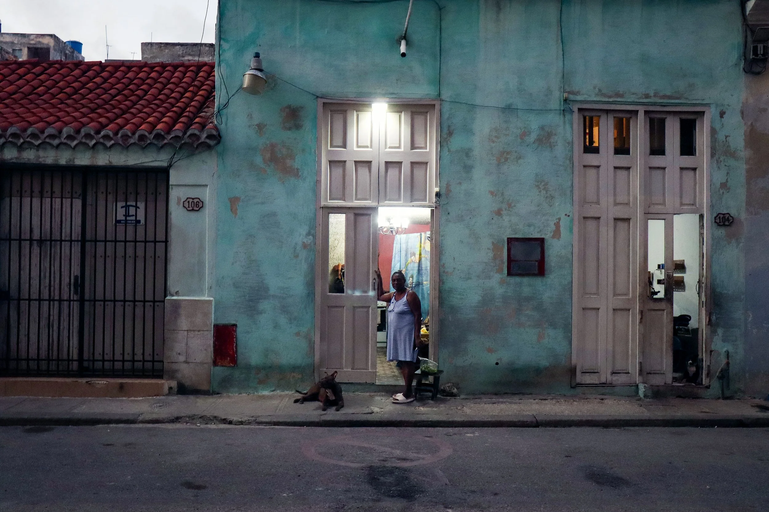 HAVANA, CUBA — March 9, 2026: A woman poses for a photograph in her doorway in Central Havana (Centro Habana). 