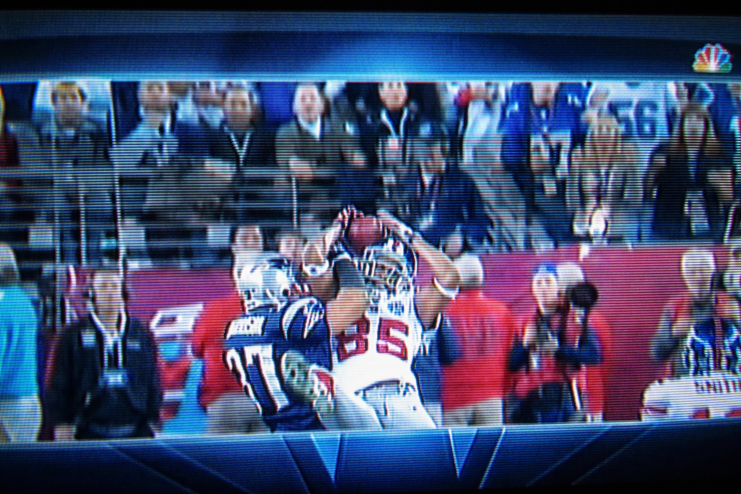 A television screenshot of photojournalist Thomas Franklin shows him holding his camera while David Tyree makes his iconic catch, which turned out to be the most important play in the game. Franklin was trying to quickly switch lenses as the play unf