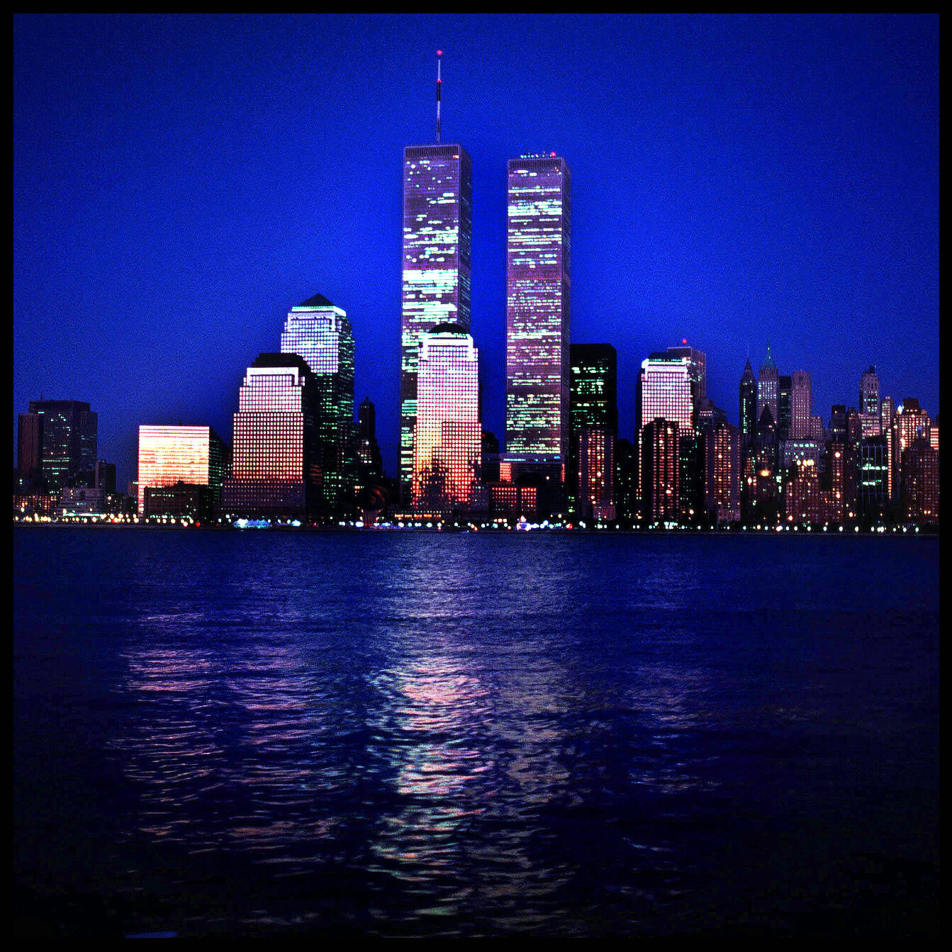 Circa 1992: The World Trade Center towers reflect the orange glow of the setting sun. The photo was taken from across the Hudson River in Jersey City.