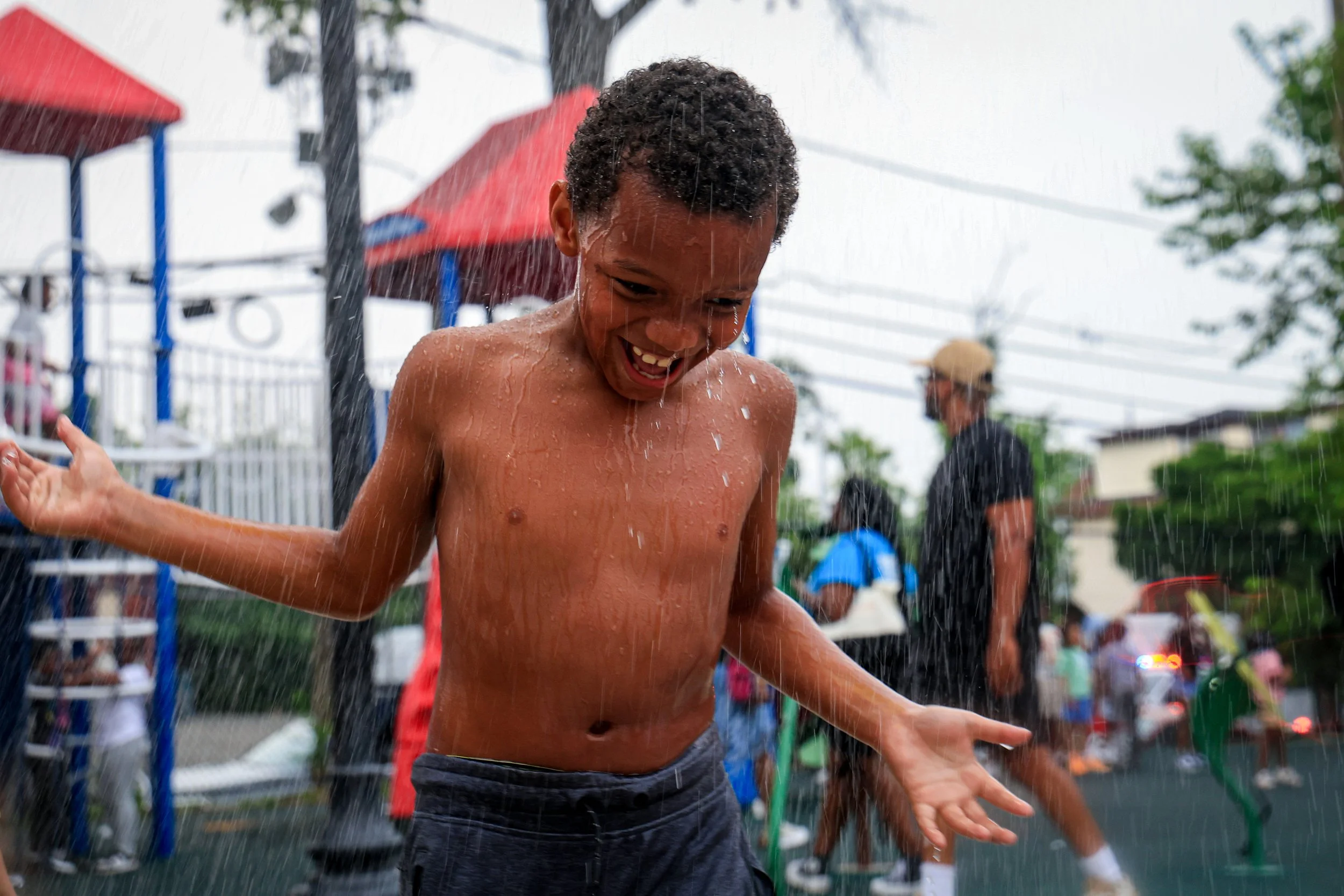 PATERSON, N.J. | Aug. 5, 2025: A young boy (name not given) plays in a sprinkler at Barbour Park during National Night Out in Paterson. The annual event brought neighbors together across all six wards with block parties, cookouts, games, music, and f