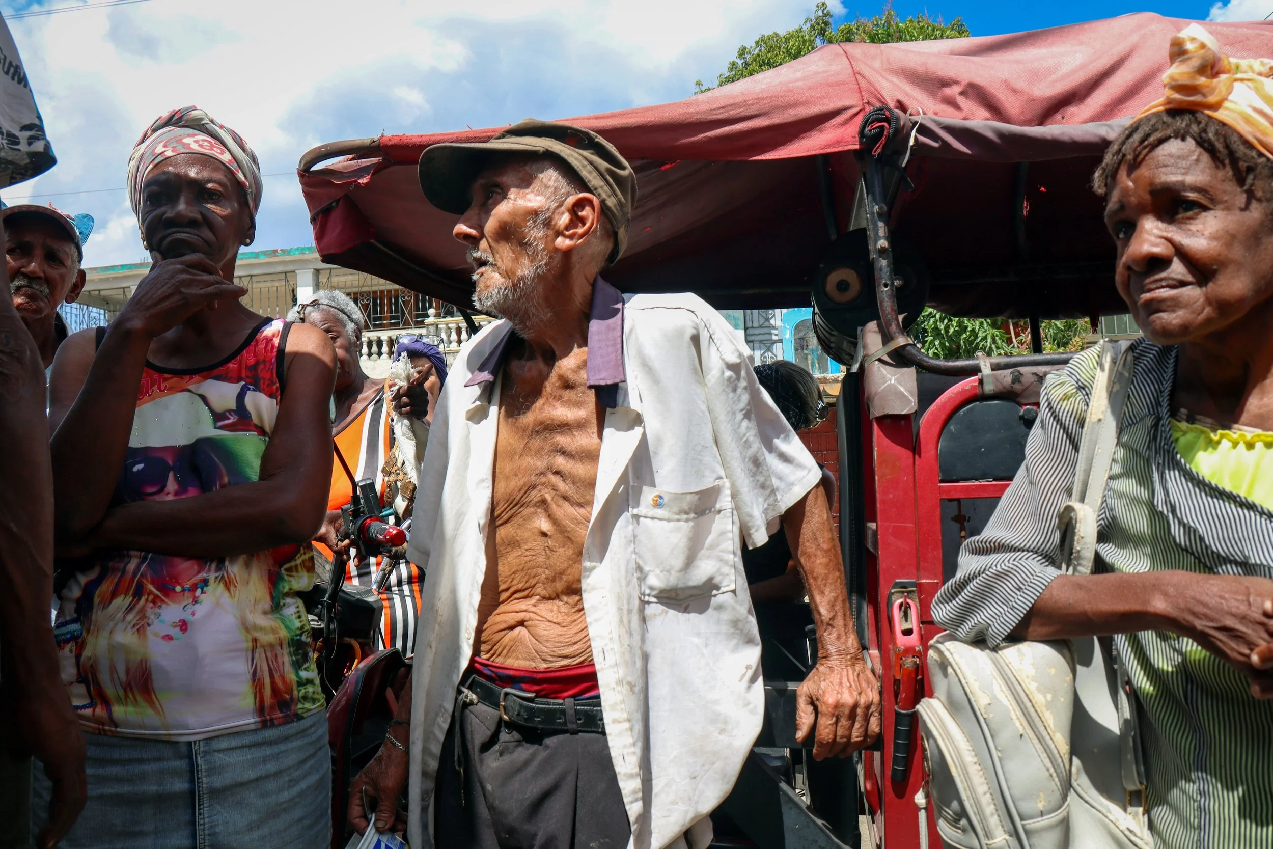 HAVANA, CUBA — March 8, 2026: Elderly residents in La Güinera wait for a meal prepared by Iliana Macias Pulido, known as “Mama,” and her team. Many show visible signs of hardship as they gather for food at the community kitchen.
