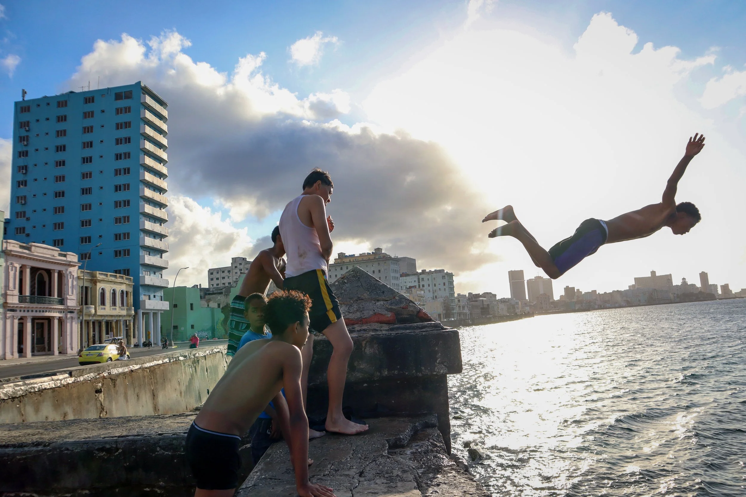 HAVANA, CUBA — March 9, 2026: A group of teenage boys cool off by jumping from the seawall along the Malecón (Malecón de La Habana).