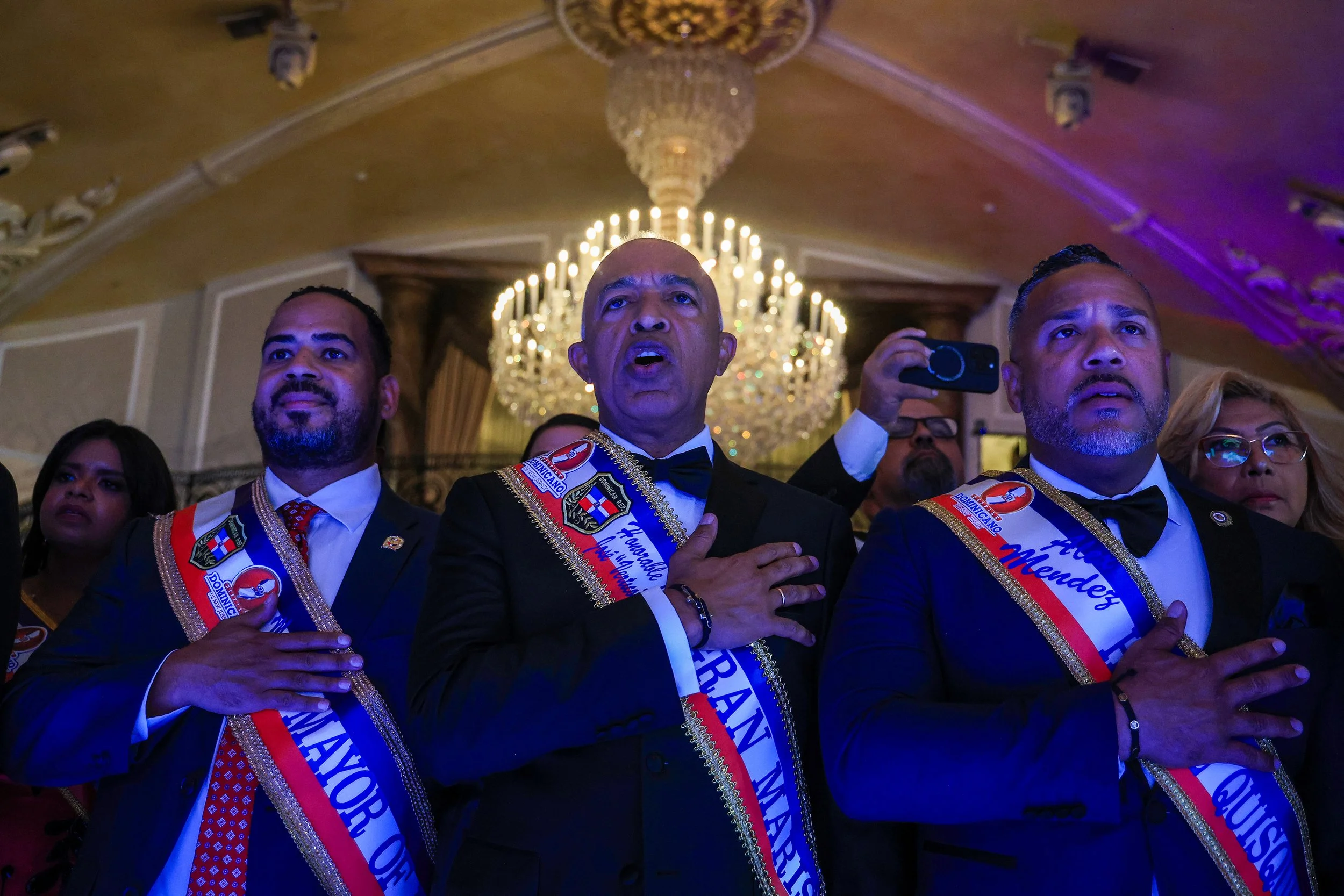 GARFIELD, N.J. | Sept. 4, 2025: Grand Marshal José Santana Suriel, Consul General of the Dominican Republic in New Jersey, stands with Passaic Mayor Hector Lora and Paterson City Councilman Luis Mendez during the Dominican national anthem at the 36th