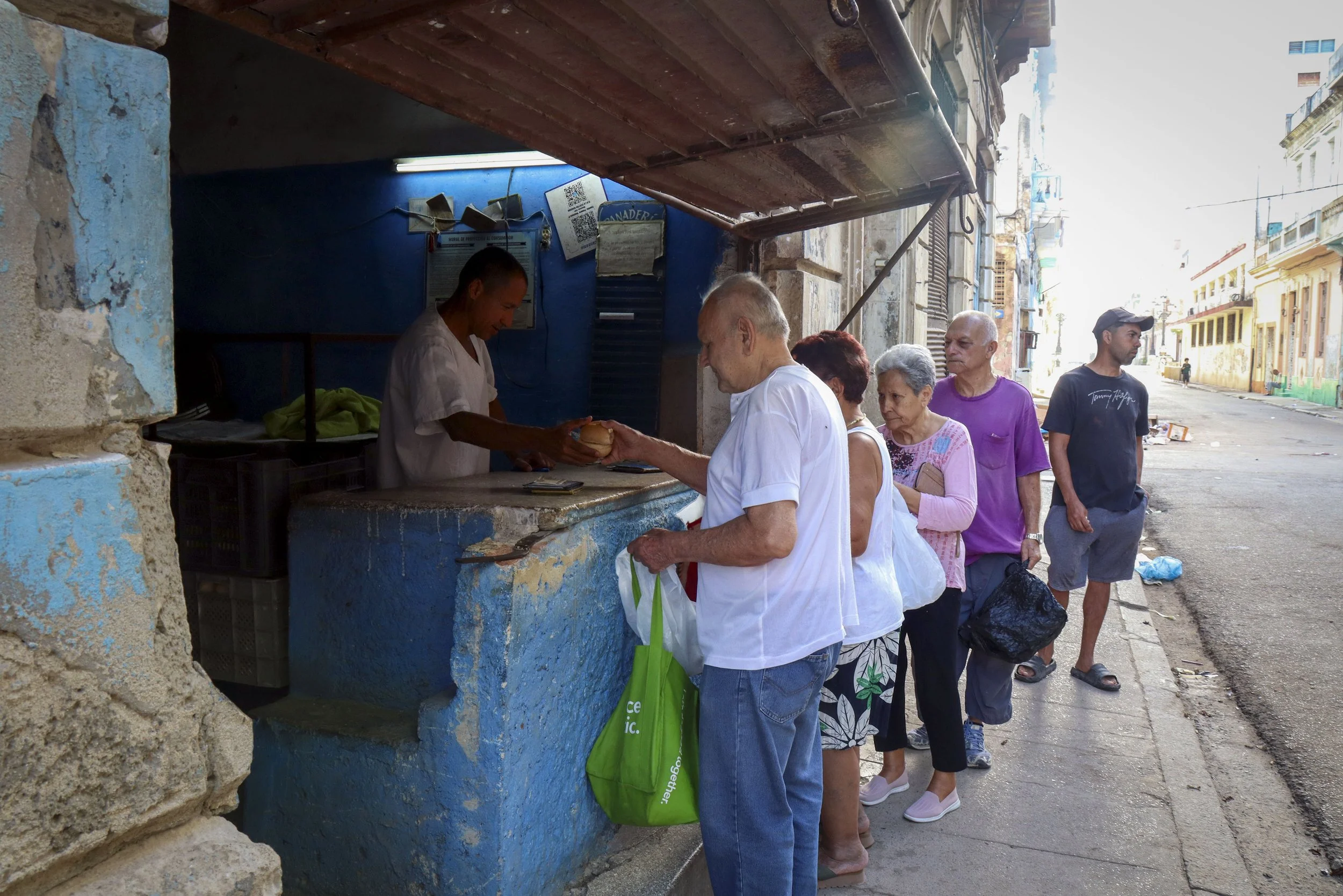 HAVANA, CUBA — March 7, 2026: Cubans wait in line for a rationed piece of bread outside a government-run bodega in Central Havana (Centro Habana). With food increasingly scarce, residents rely on the libreta de abastecimiento, the state-issued ration