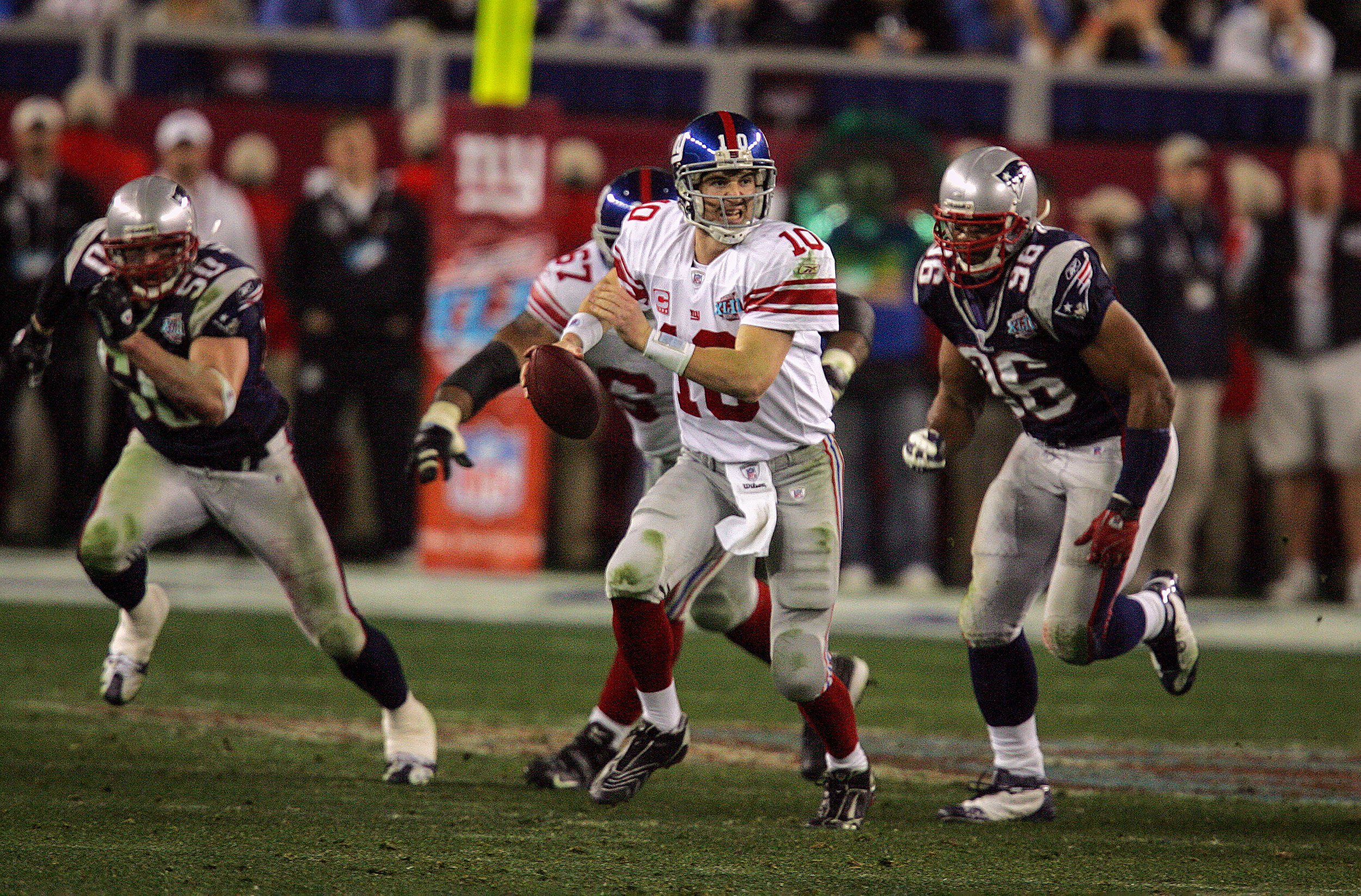 Giants QB Eli Manning attempts a pass under pressure for Patriots defenders