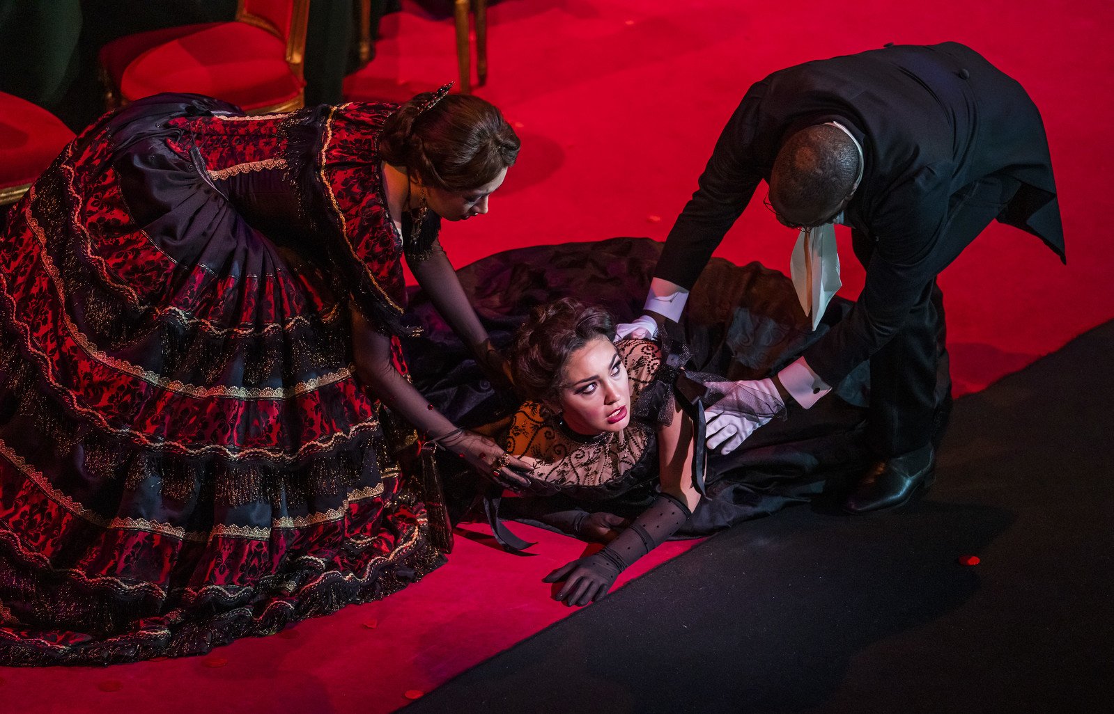 Hongni Wu as Flora Bervoix, Kristina Mkhitaryan as Violetta Valéry and Simon Shibambu as Doctor Grenvil in La traviata, The Royal Opera ©2021 ROH. Photograph by Tristram Kenton.