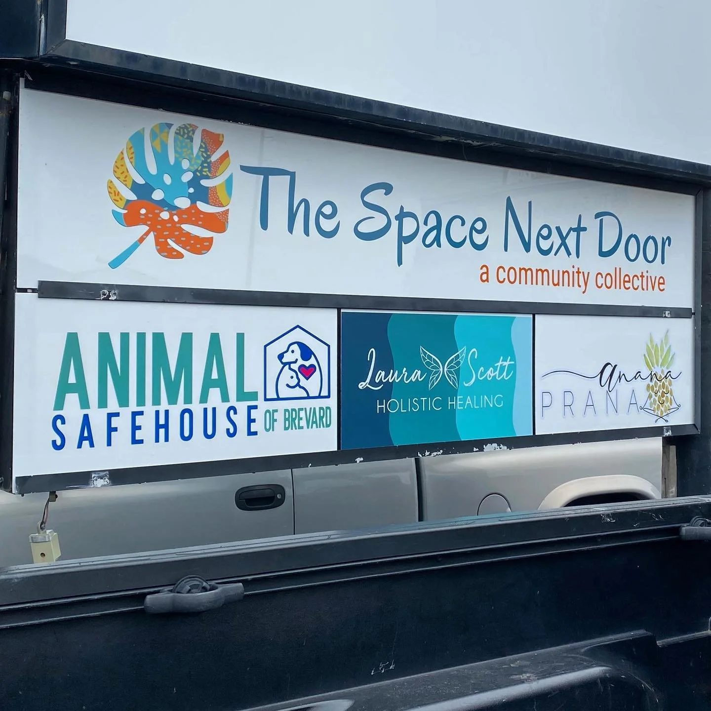 animal safehouse sign beneath a sign that reads 'the space next door'