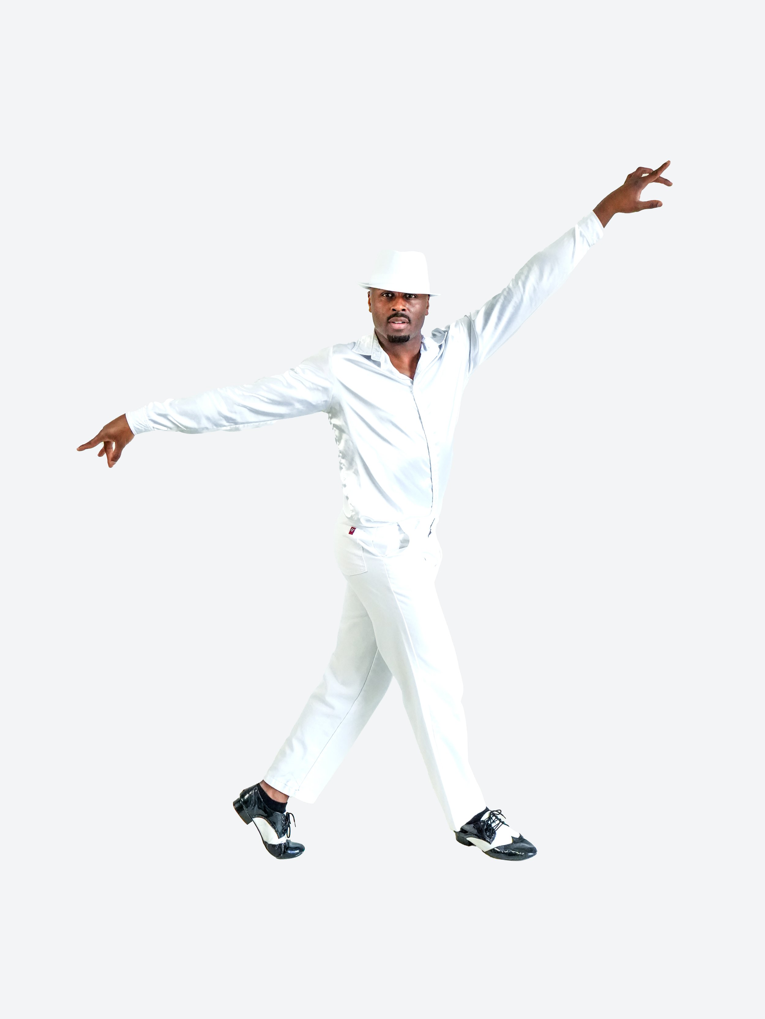 A man dressed in a white suit, hat, and black shoes striking a dance pose with arms extended, standing against a plain white background.