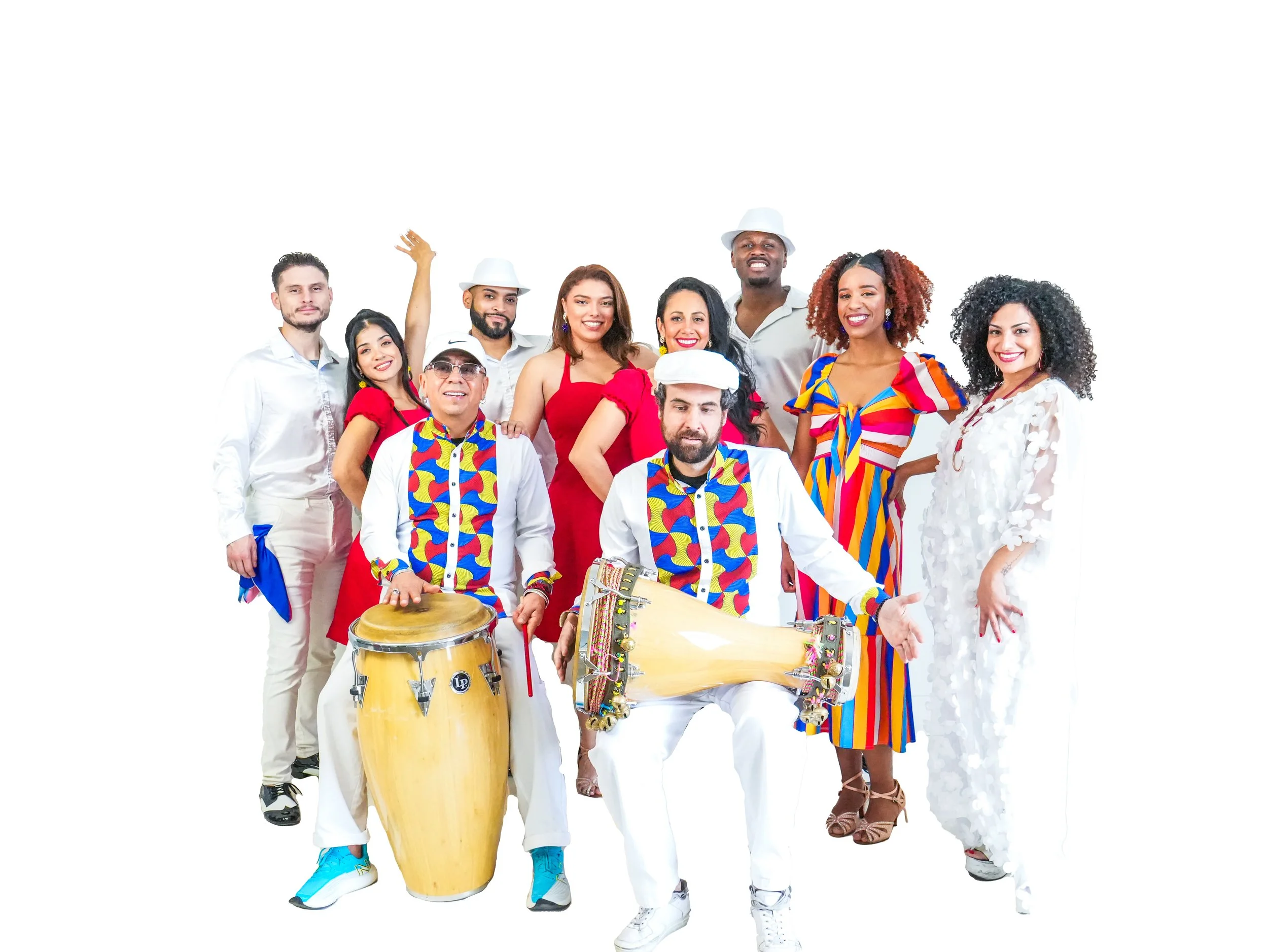 Group of people celebrating, some wearing colorful costumes, with two men in front playing drums, on a white background