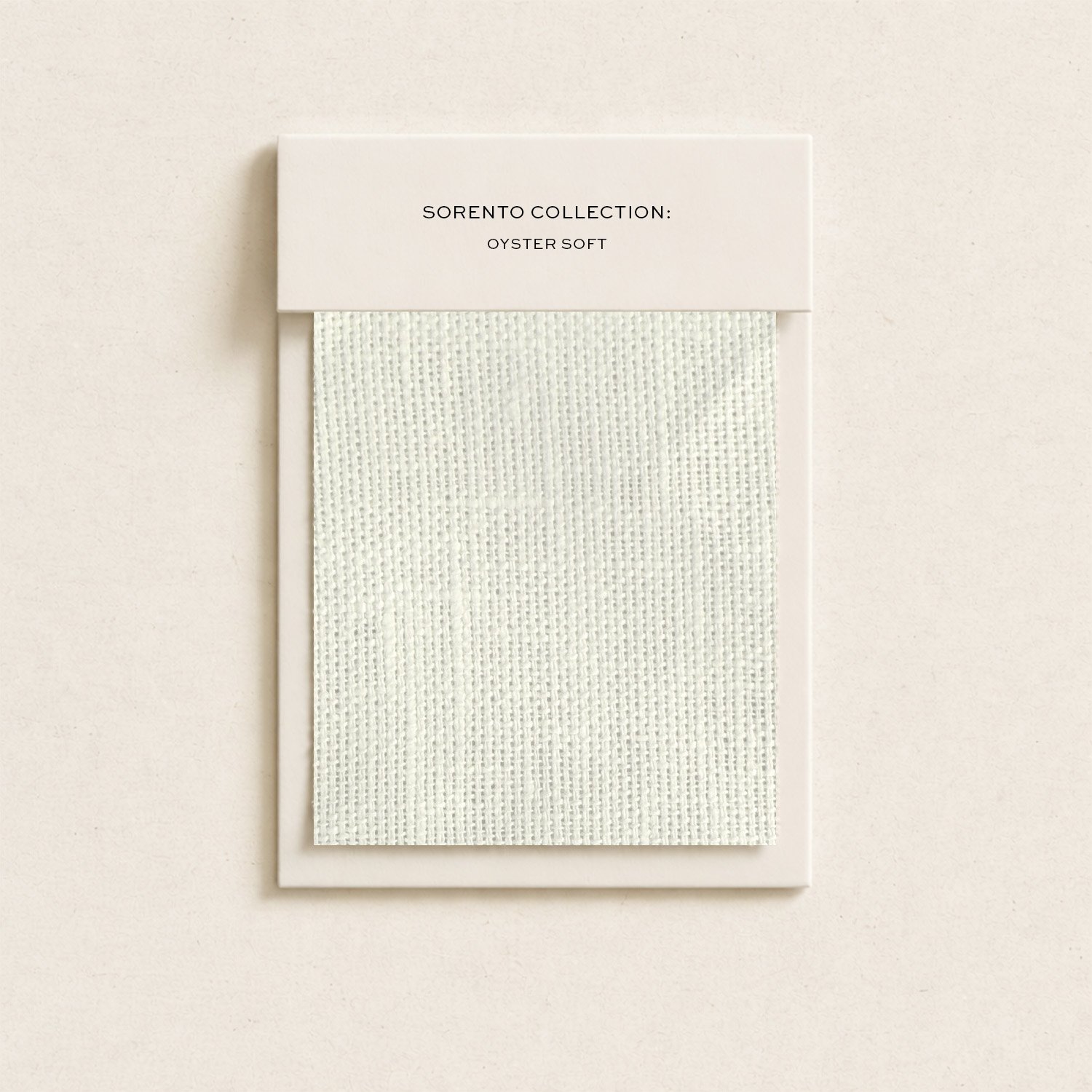 A white box labeled 'Sorento Collection: Oyster Soft' containing a textured fabric sample, mounted on a plain wall.