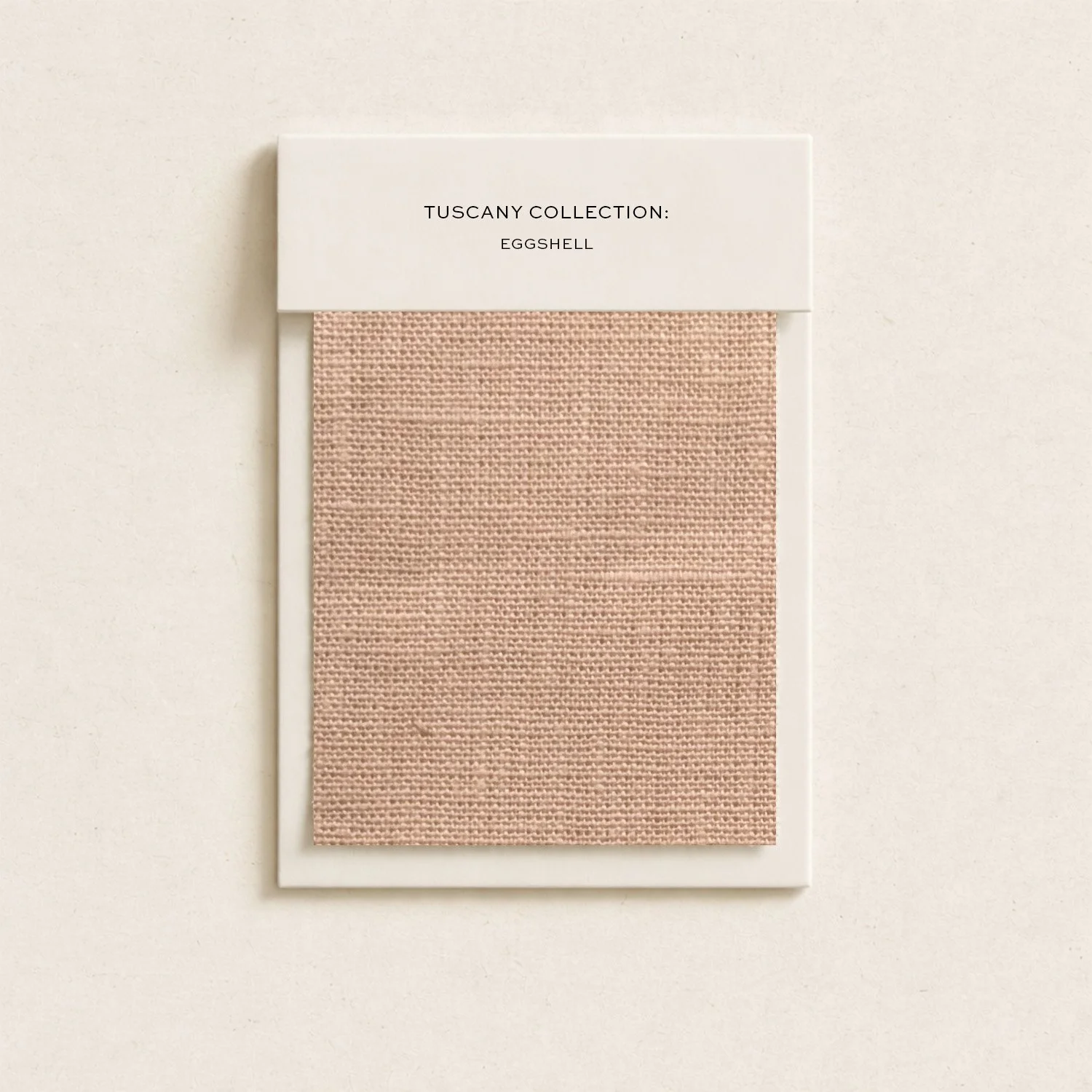 A fabric sample card from the Tuscany Collection: Eggshell, showing a beige textured fabric material.
