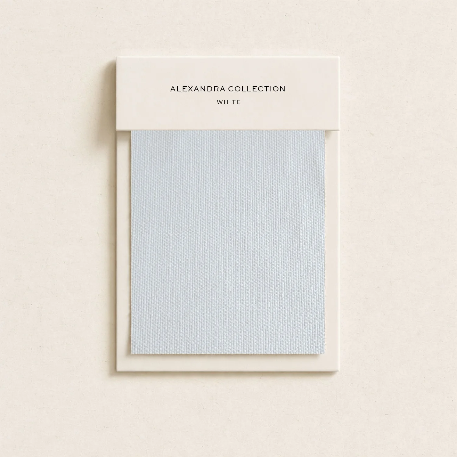A white door hanger with a blank white fabric panel below a cardboard header that reads "ALEXANDRA COLLECTION WHITE" against a white wall background.