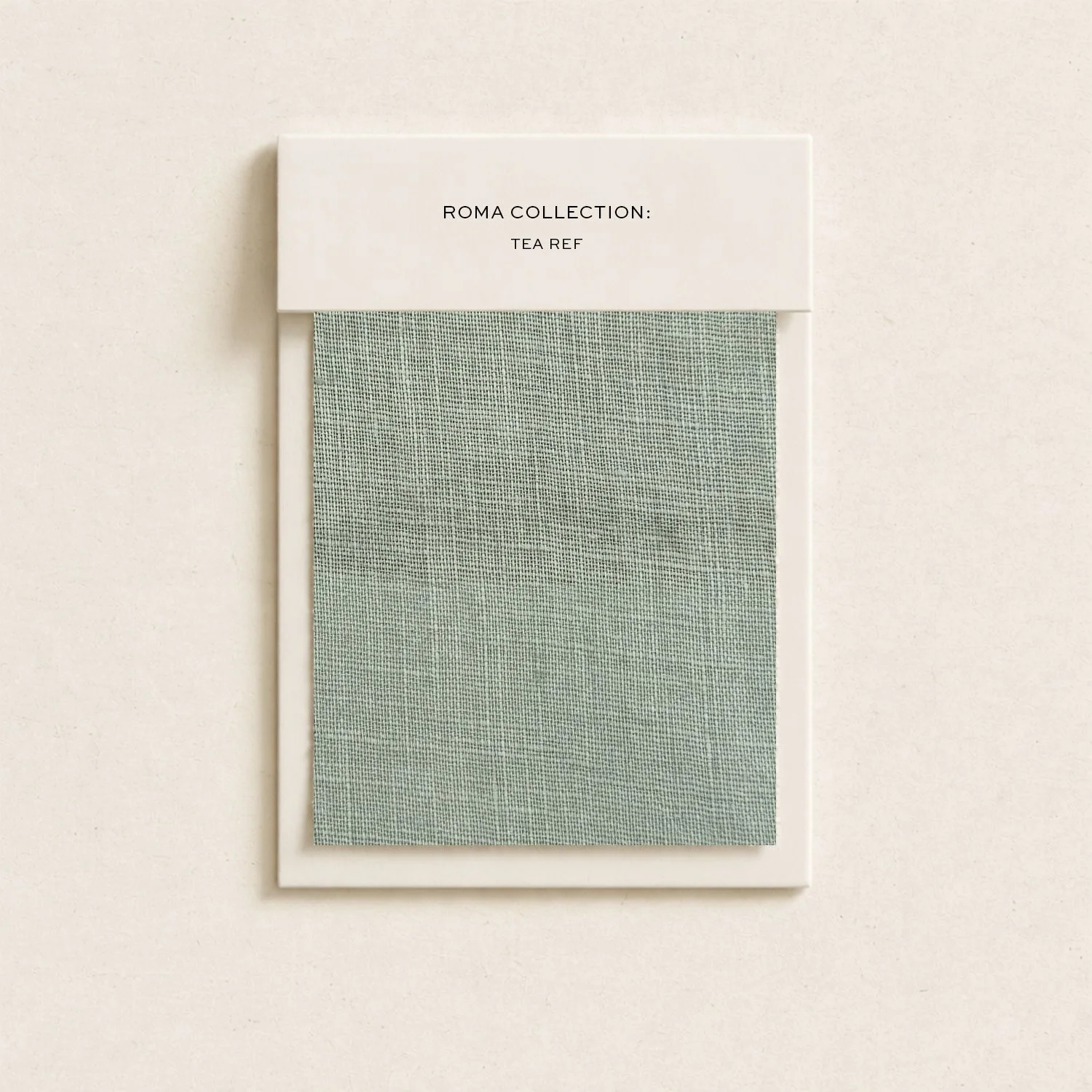 A white packaging box with black text that reads 'Roma Collection: Tea Ref'. Below the box, a textured green fabric swatch is displayed on a white background.
