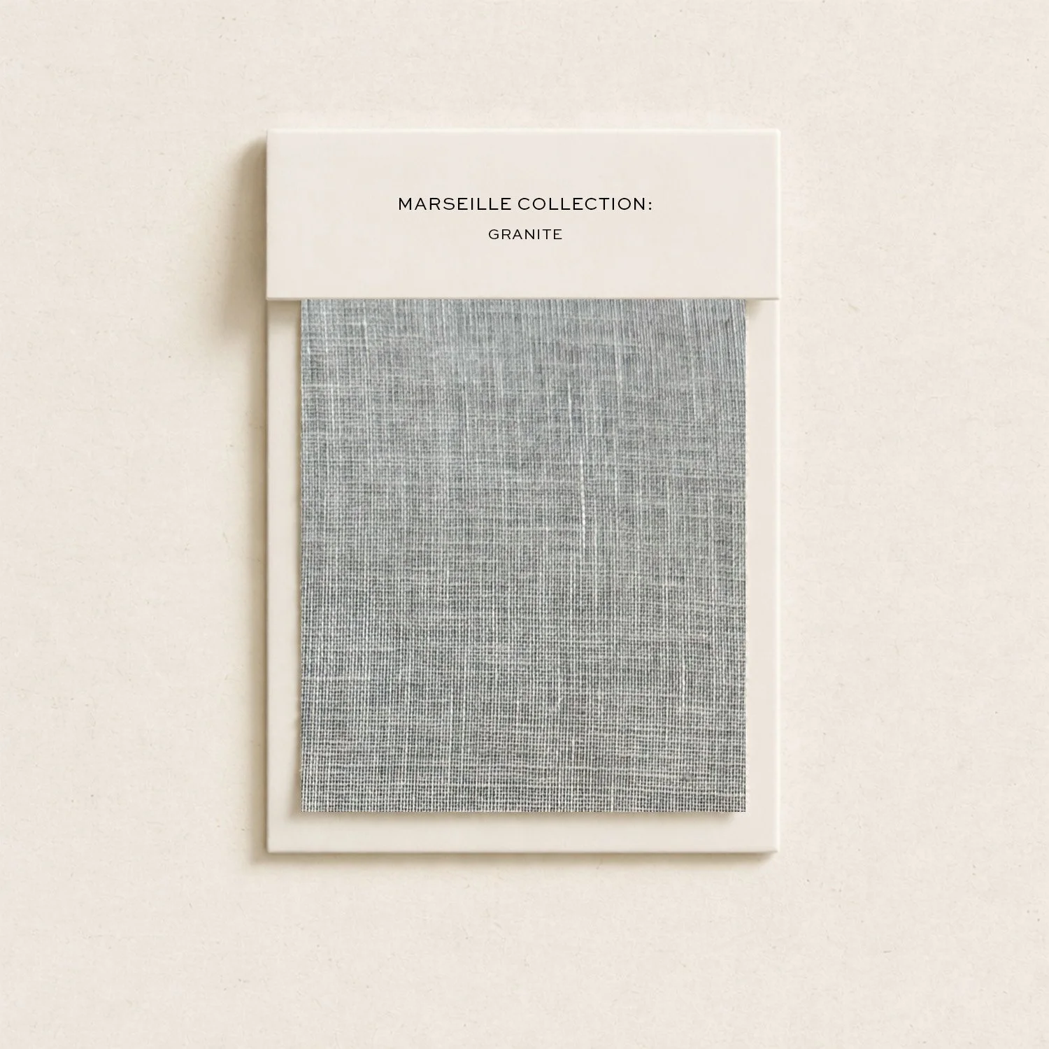 A fabric sample card with a grey granite patterned fabric, labeled 'Marseille Collection: Granite'.