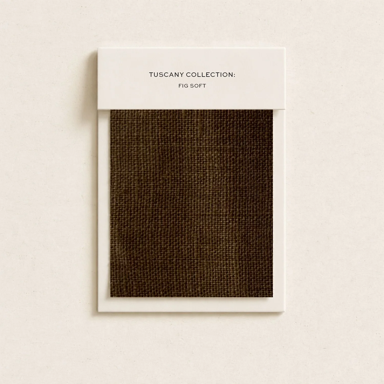 Sample swatch of Tuscany Collection: Fig Soft fabric in a beige frame, mounted on a white wall.