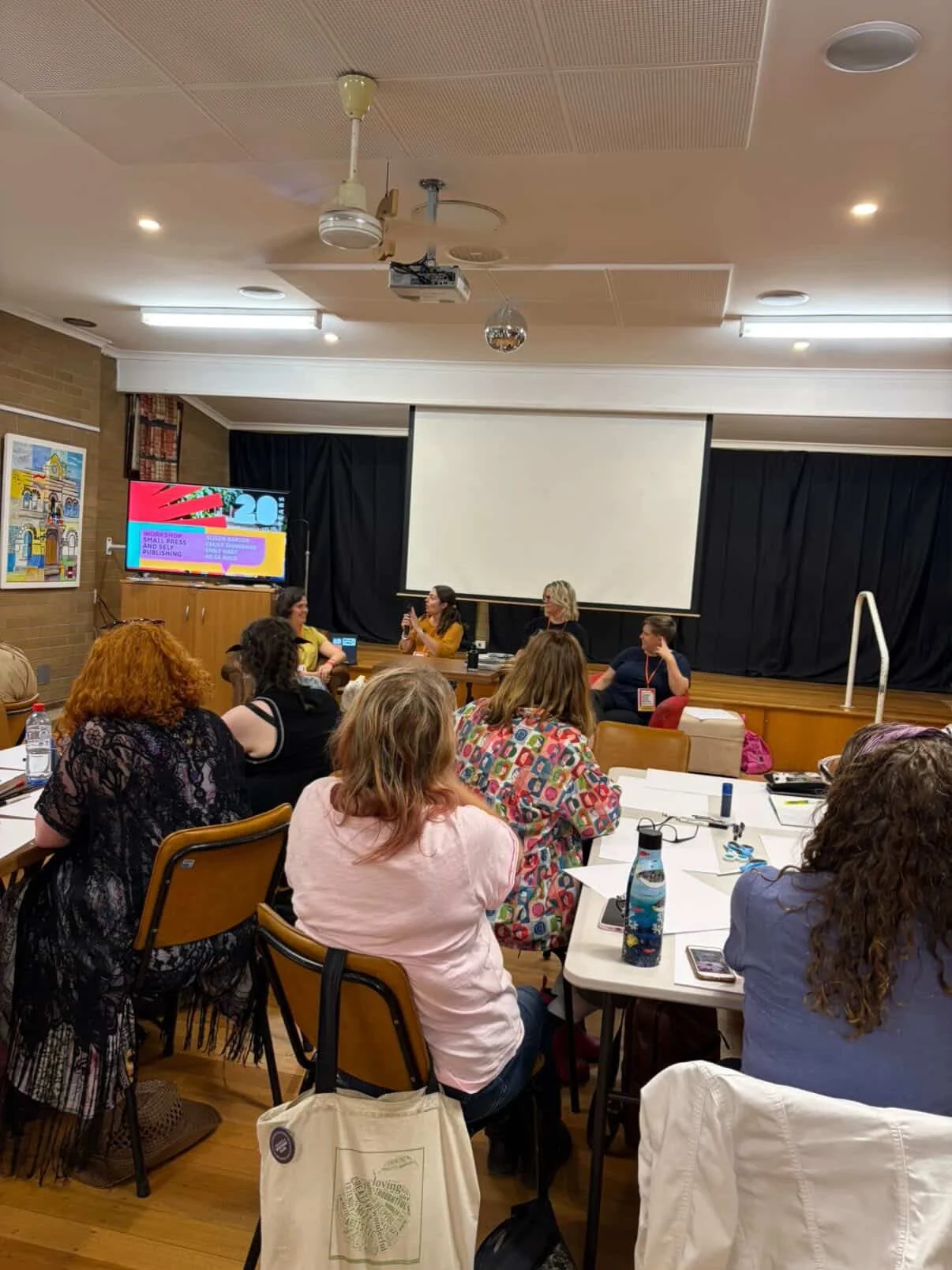 Cecile talks into the microphone at a publishing workshop
