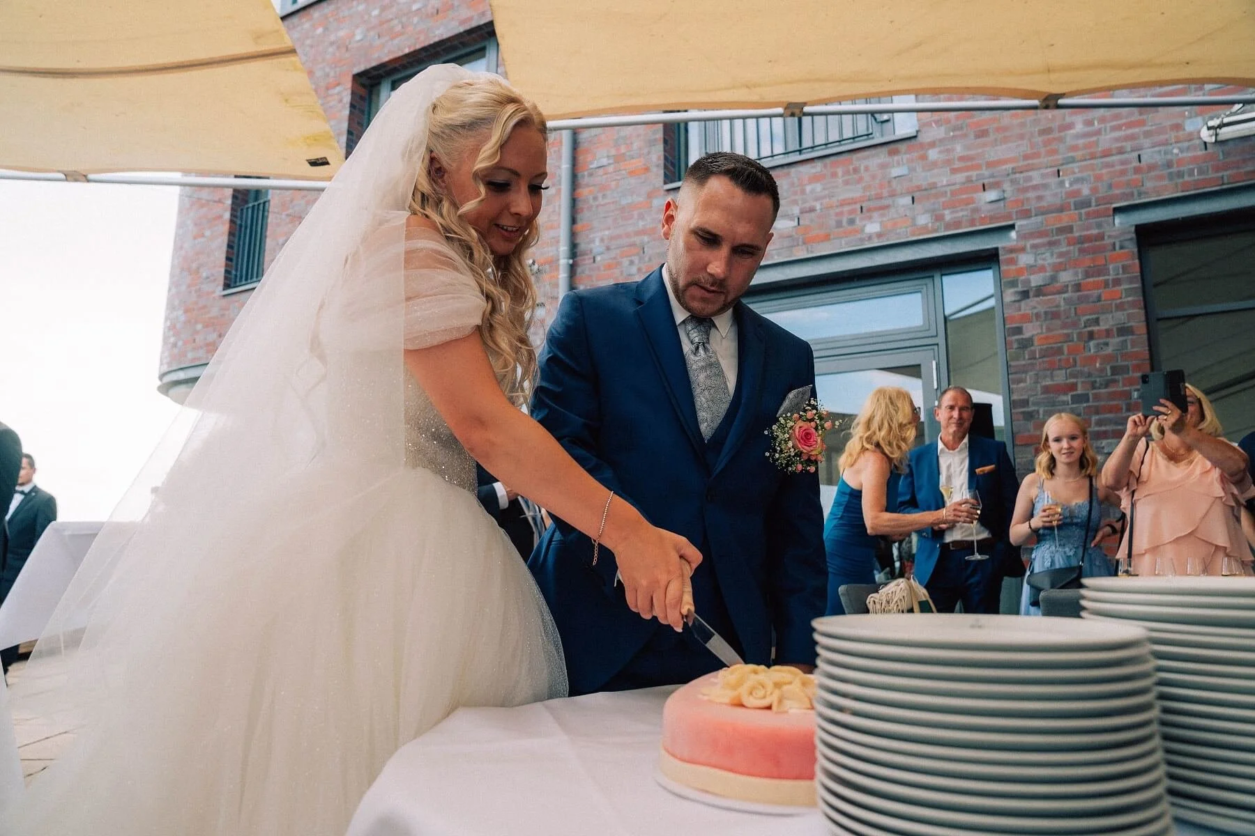 Hochzeitspaar schneidet den Kuchen an.