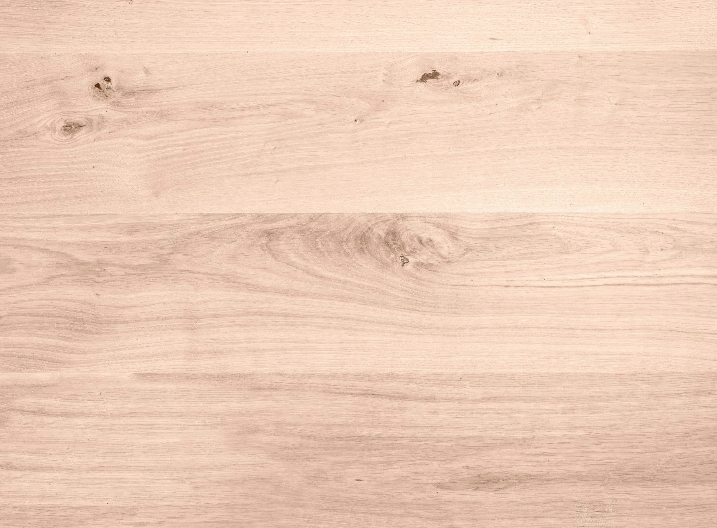 A light-colored wooden surface with visible wood grain and knots.