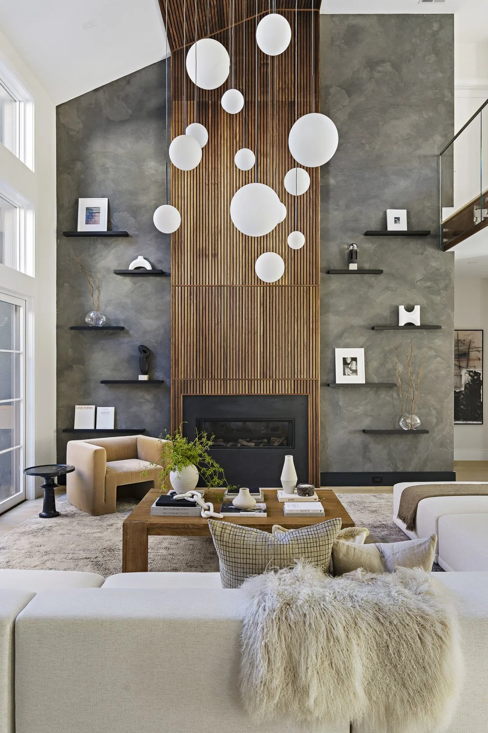 The living room with the textured accent wall + hanging globe lights