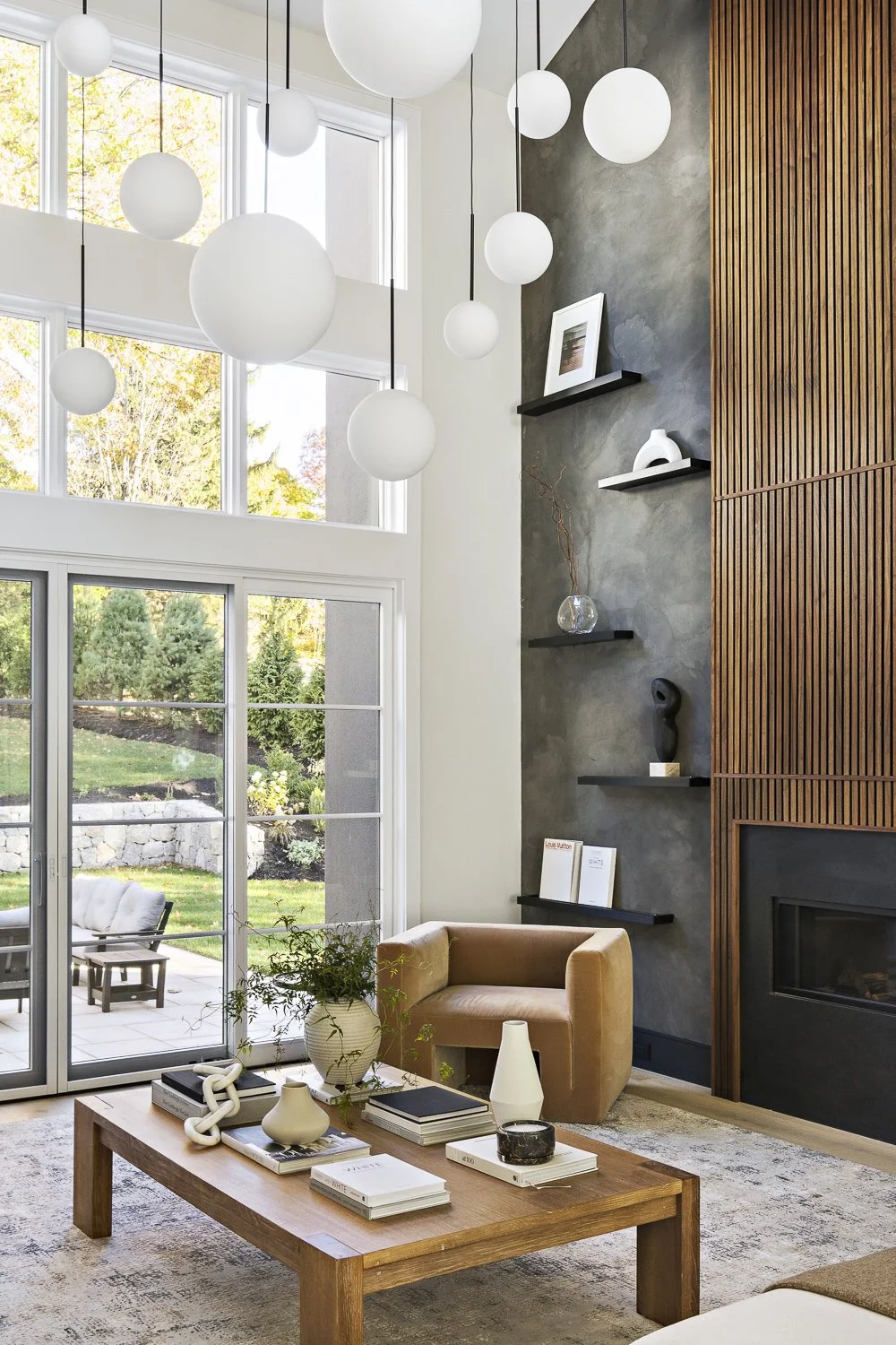 The living room with the textured accent wall + hanging globe lights