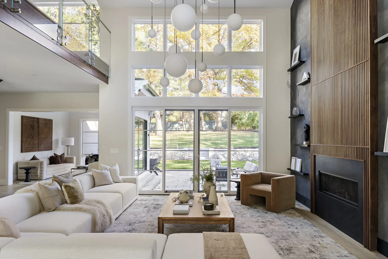 The living room with the textured accent wall + hanging globe lights