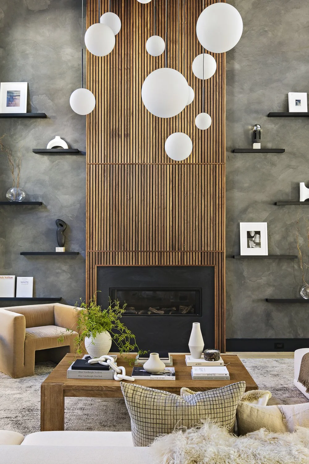 The living room with the textured accent wall + hanging globe lights